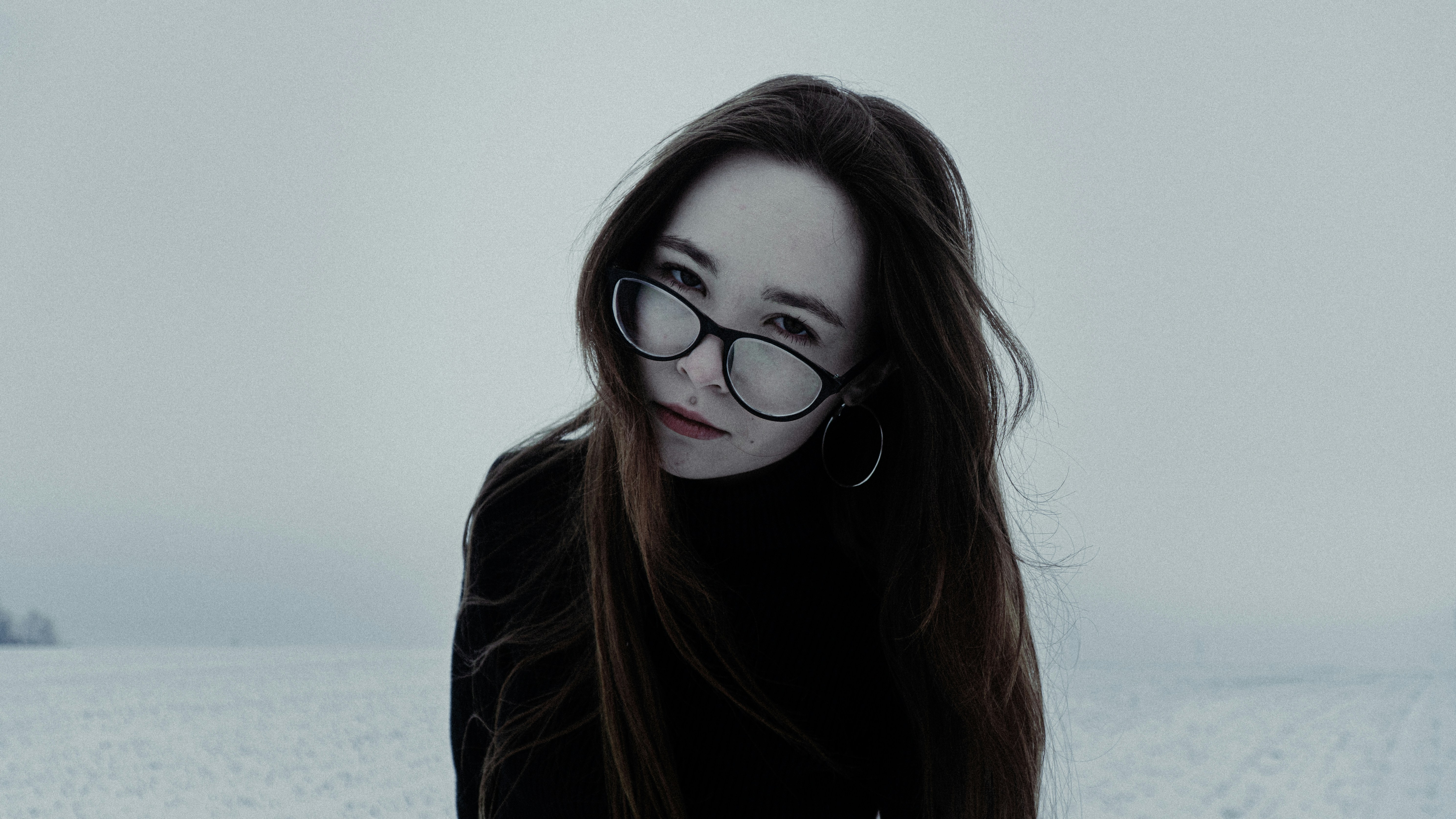 Young woman with glasses in a snowy field