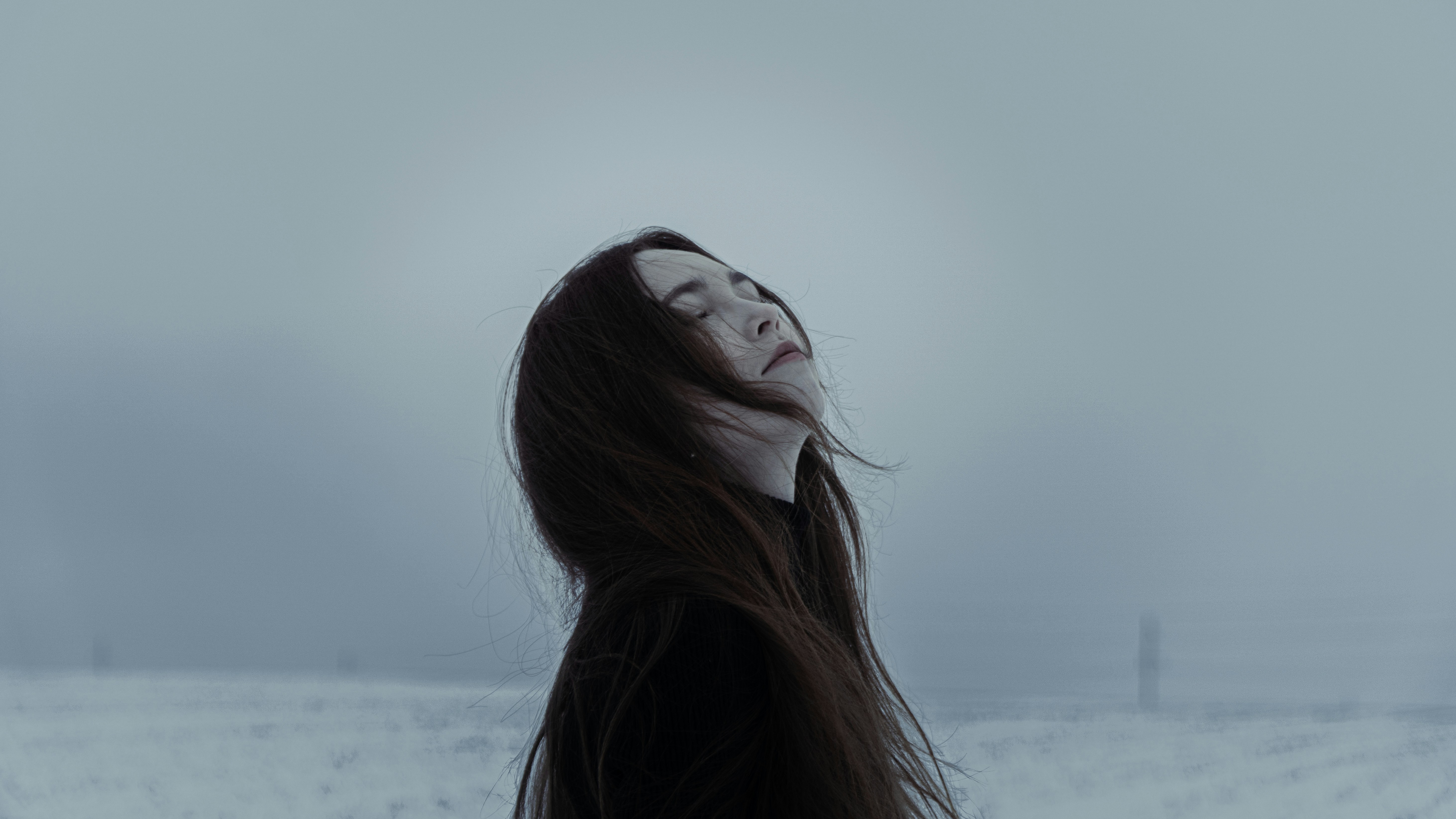 Woman with long dark hair in a snowy field