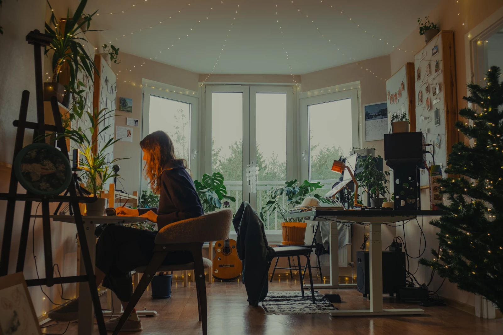 A provider working calmly at a warm, plant-filled desk with paperwork sorted