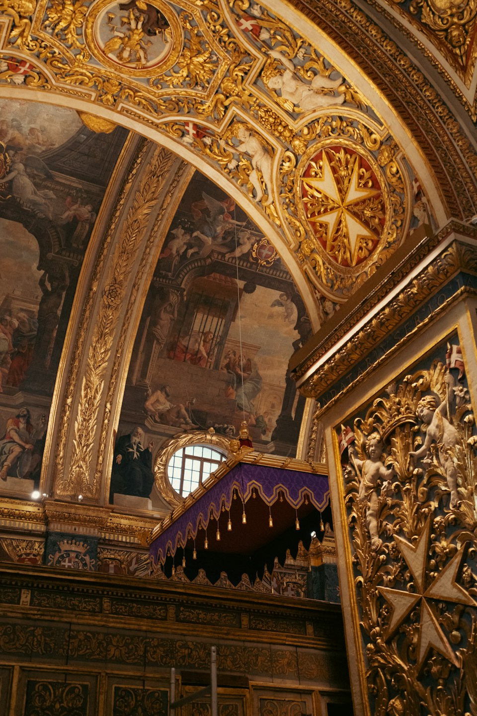Gilded Baroque ceiling and a Maltese cross inside St. John's Co-Cathedral, Valletta