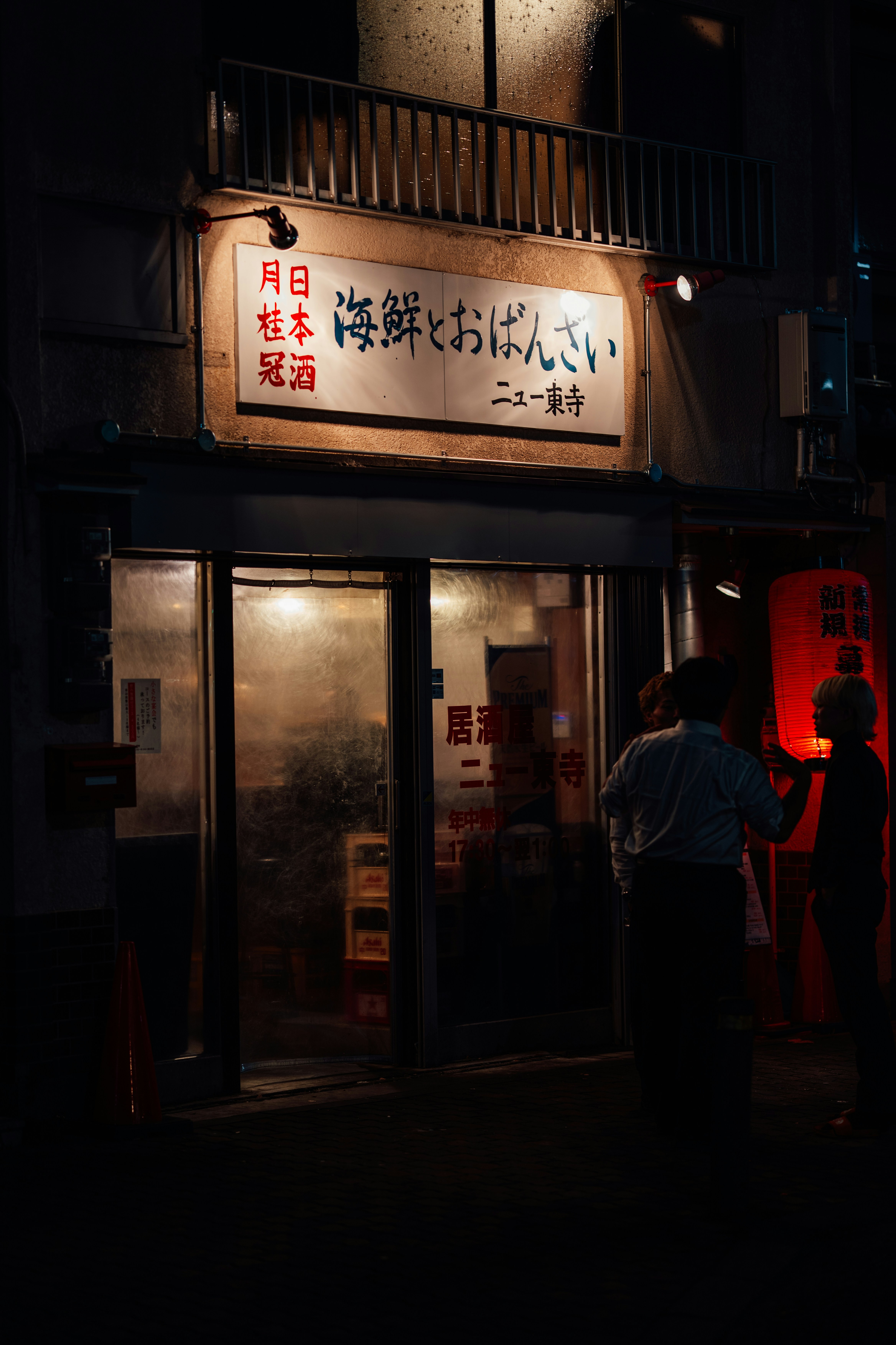 People standing outside a japanese restaurant at night