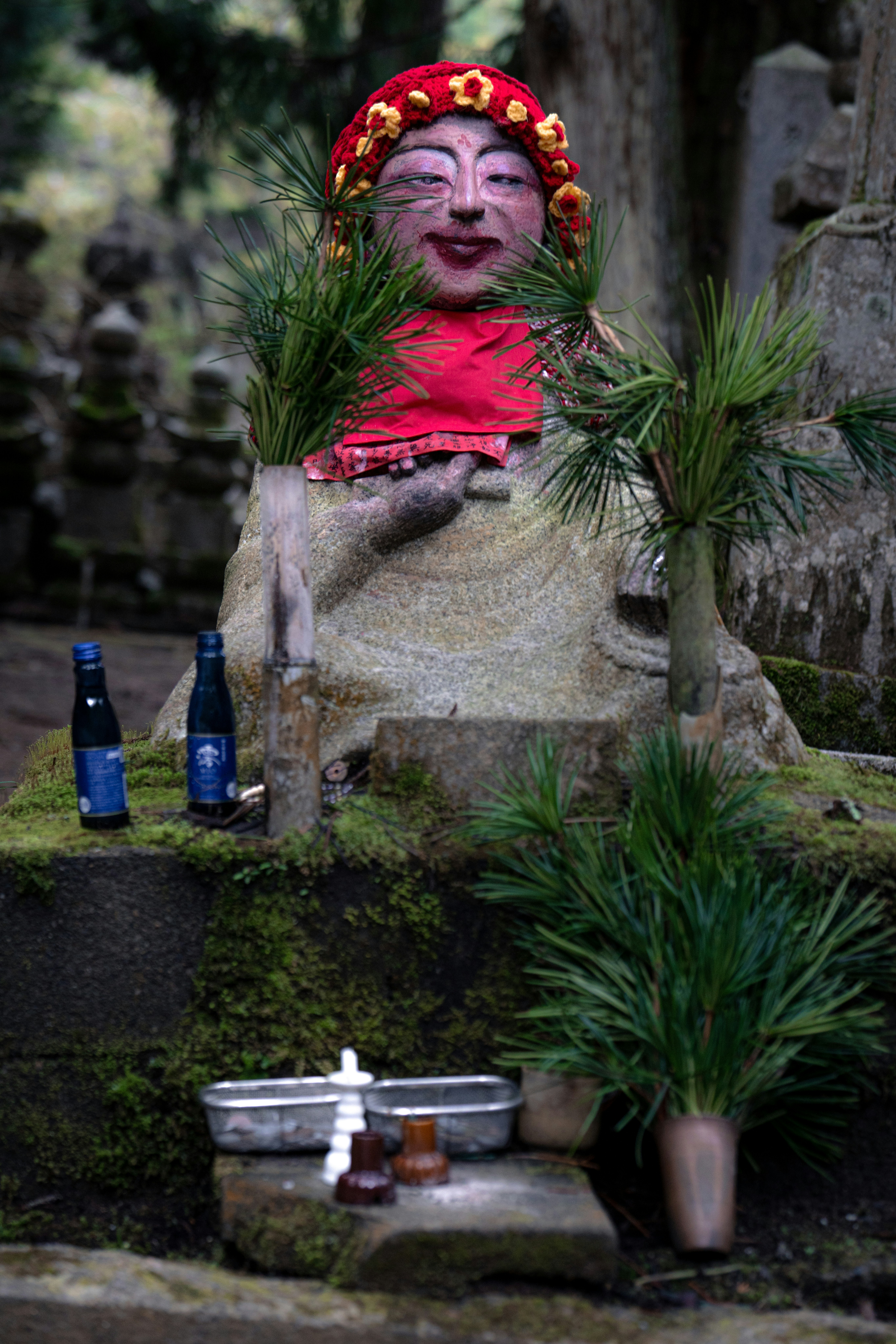 赤い布と緑で飾られた石像。