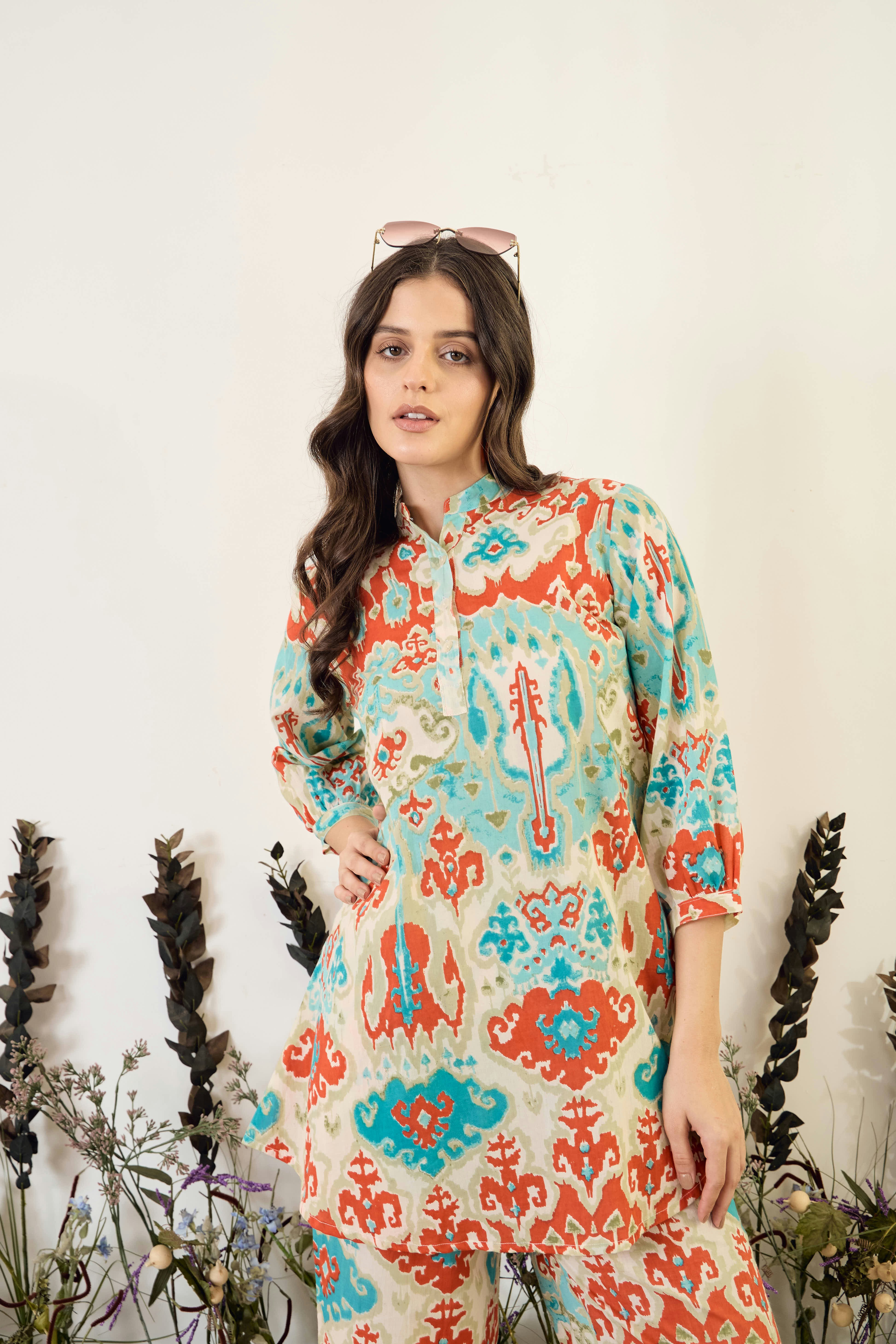 Woman wearing a colorful patterned tunic and pants