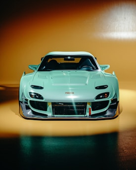 A light blue sports car with a wide body kit.