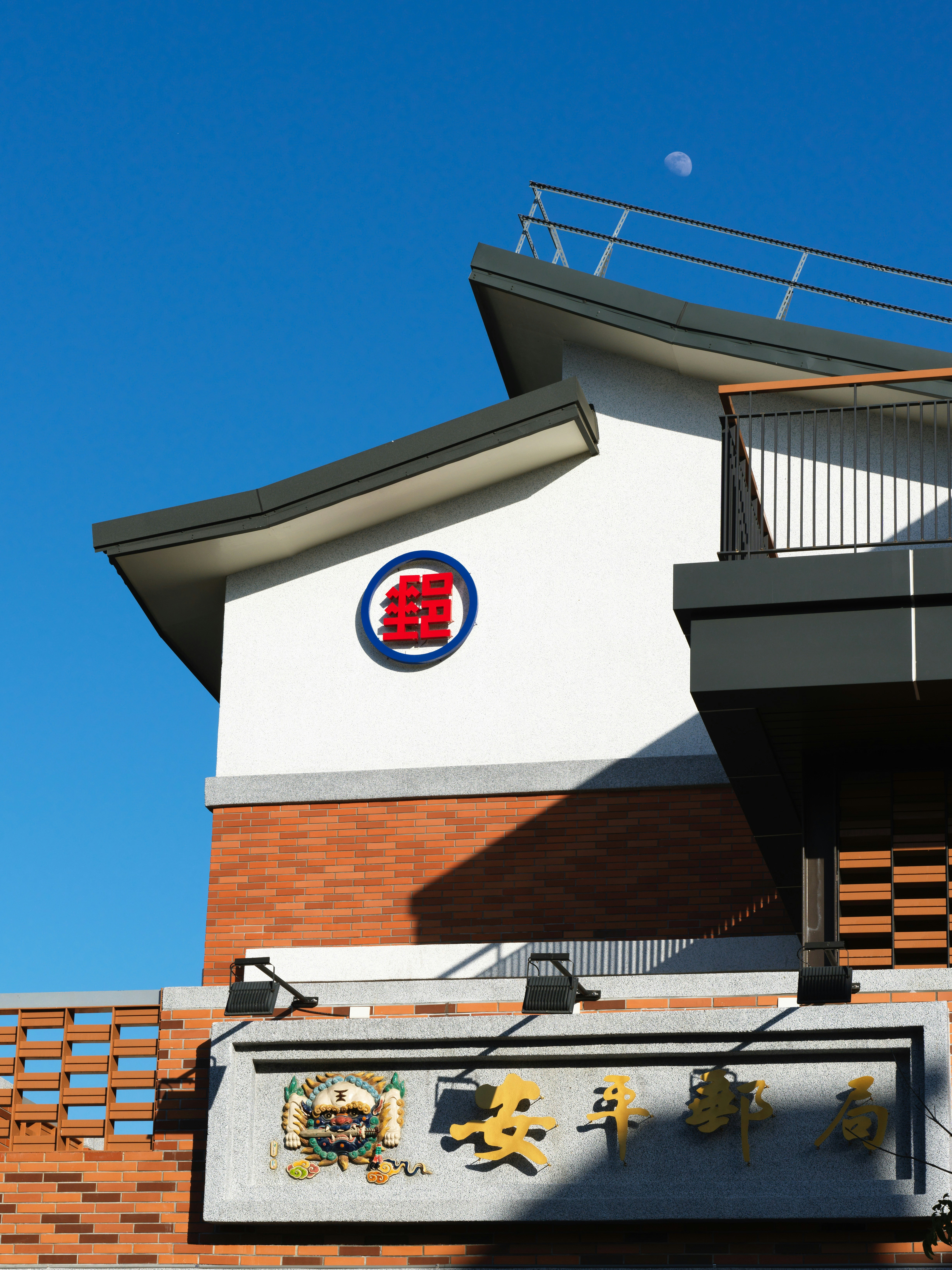 Modern building facade with circular logo and moon.