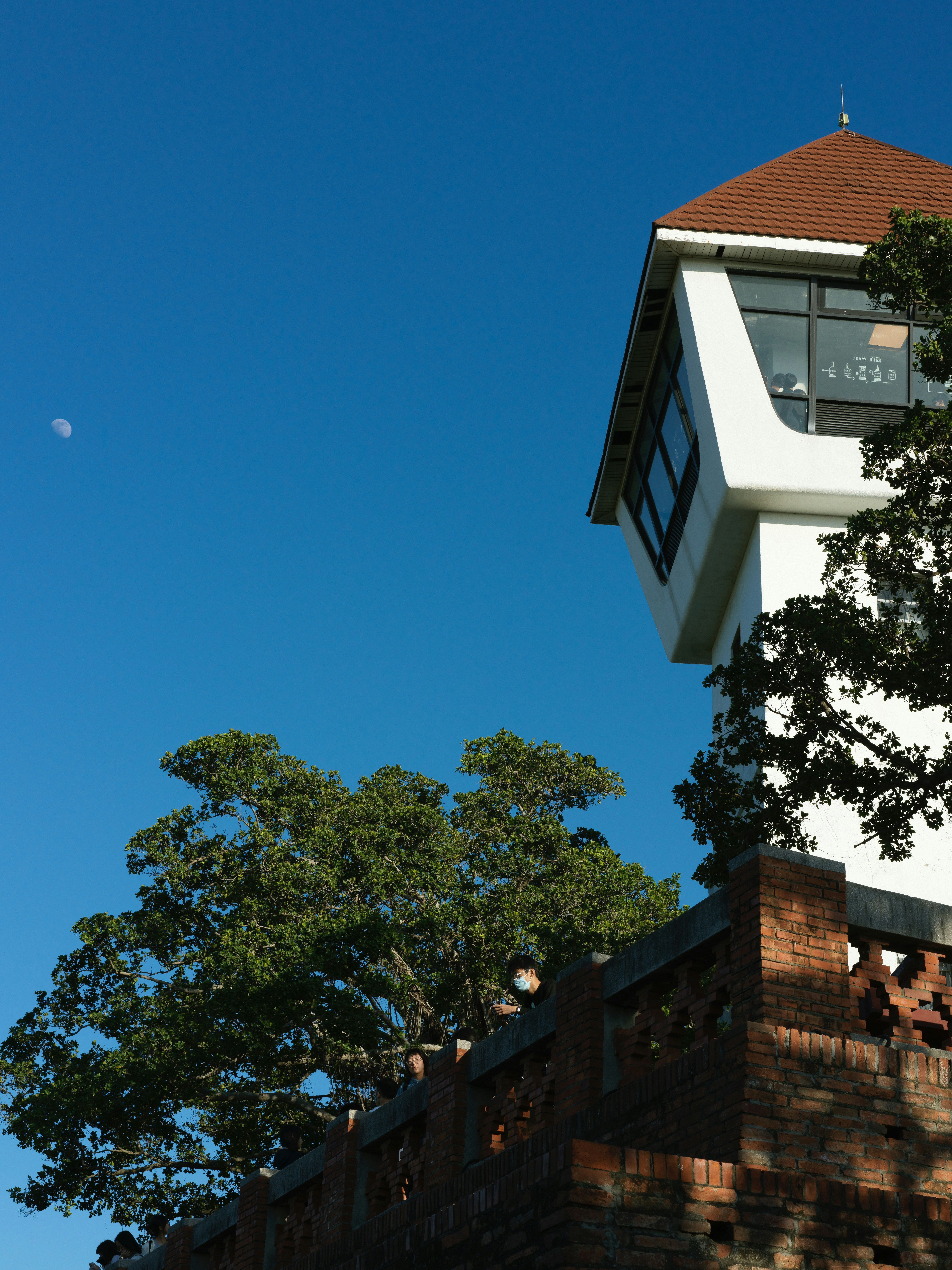 White tower with red roof against clear blue sky