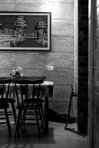 A still life of a table, chairs, and a skateboard.