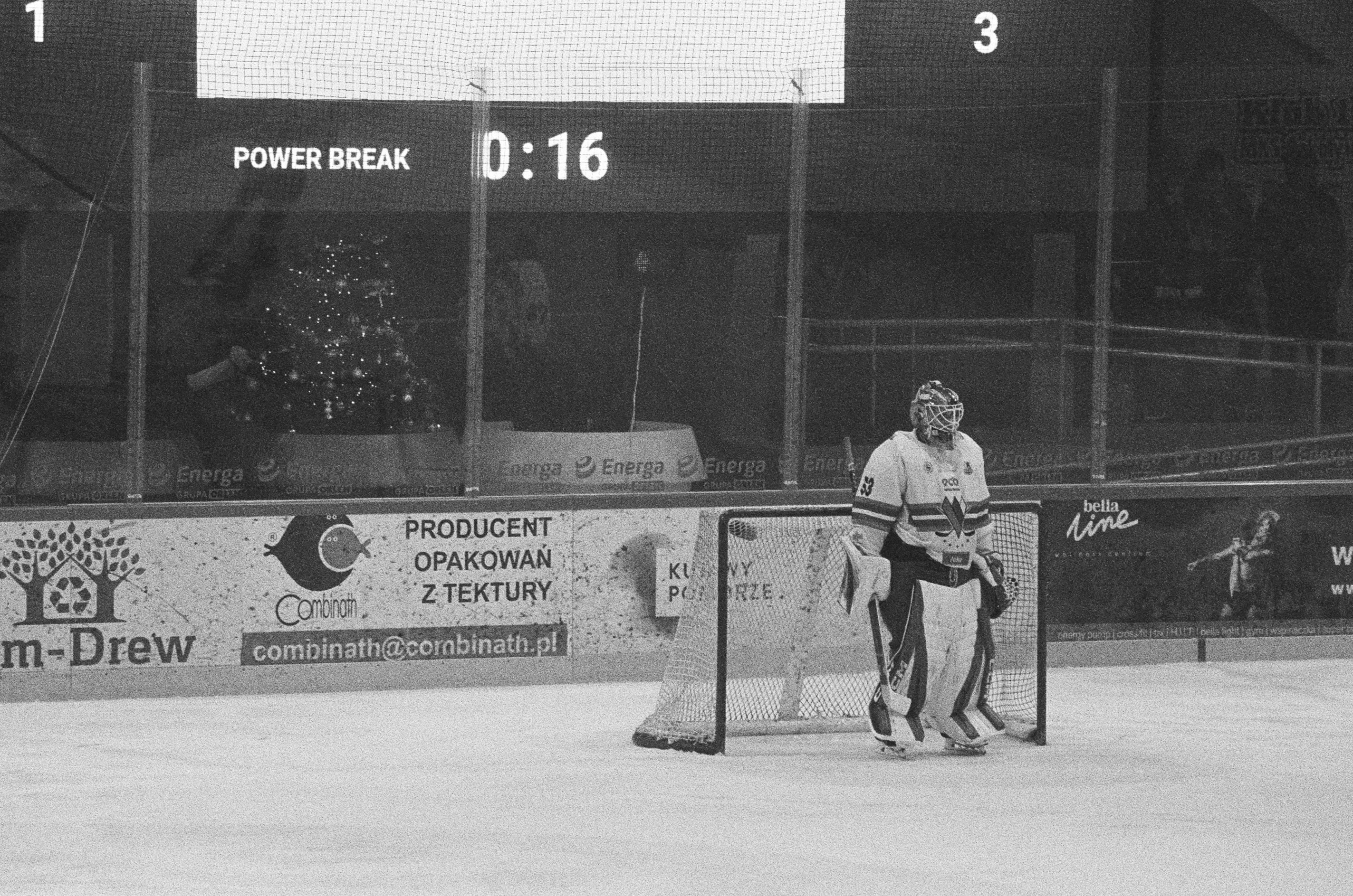A hockey goalie stands on the ice near the net.