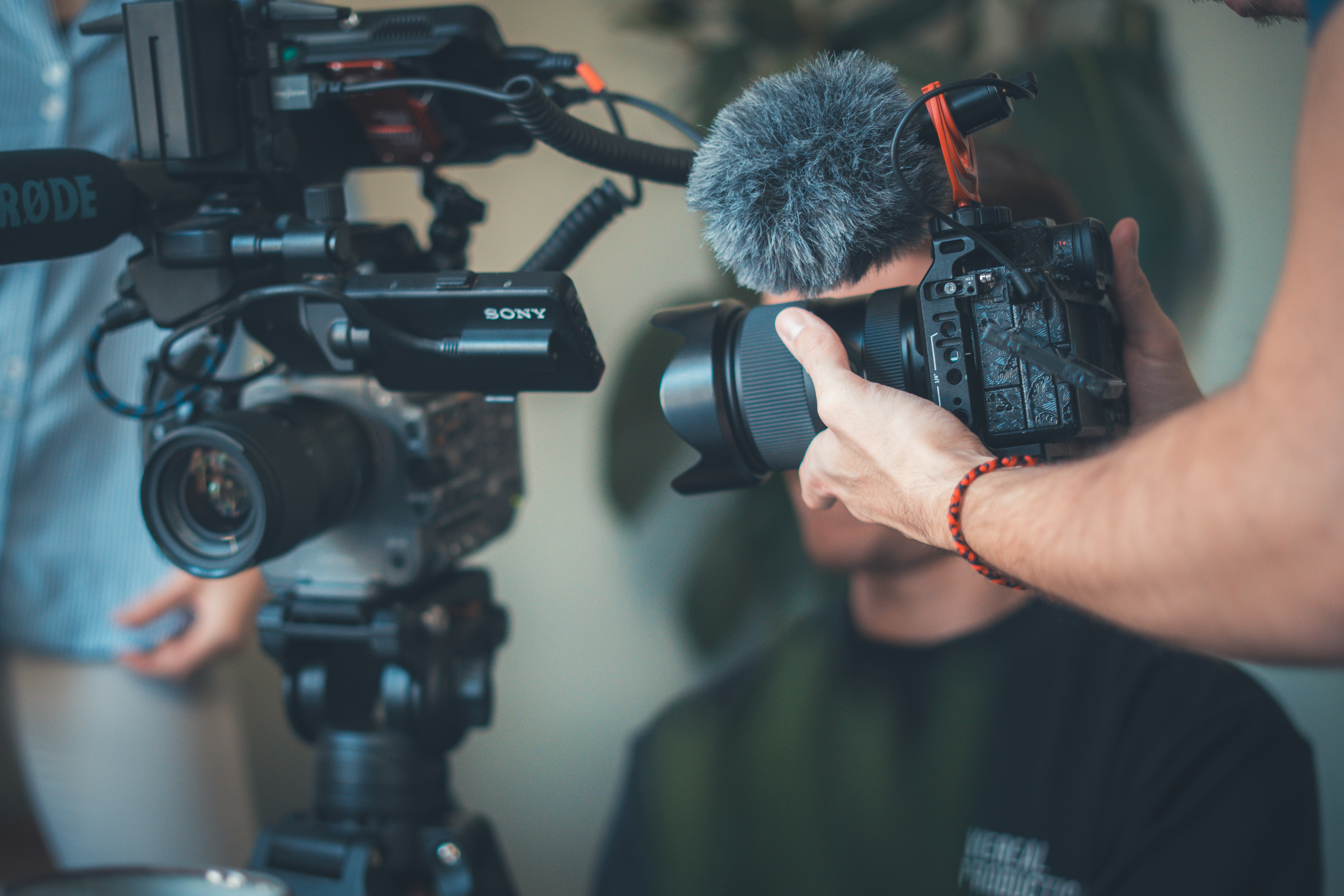 Two people operating professional video cameras