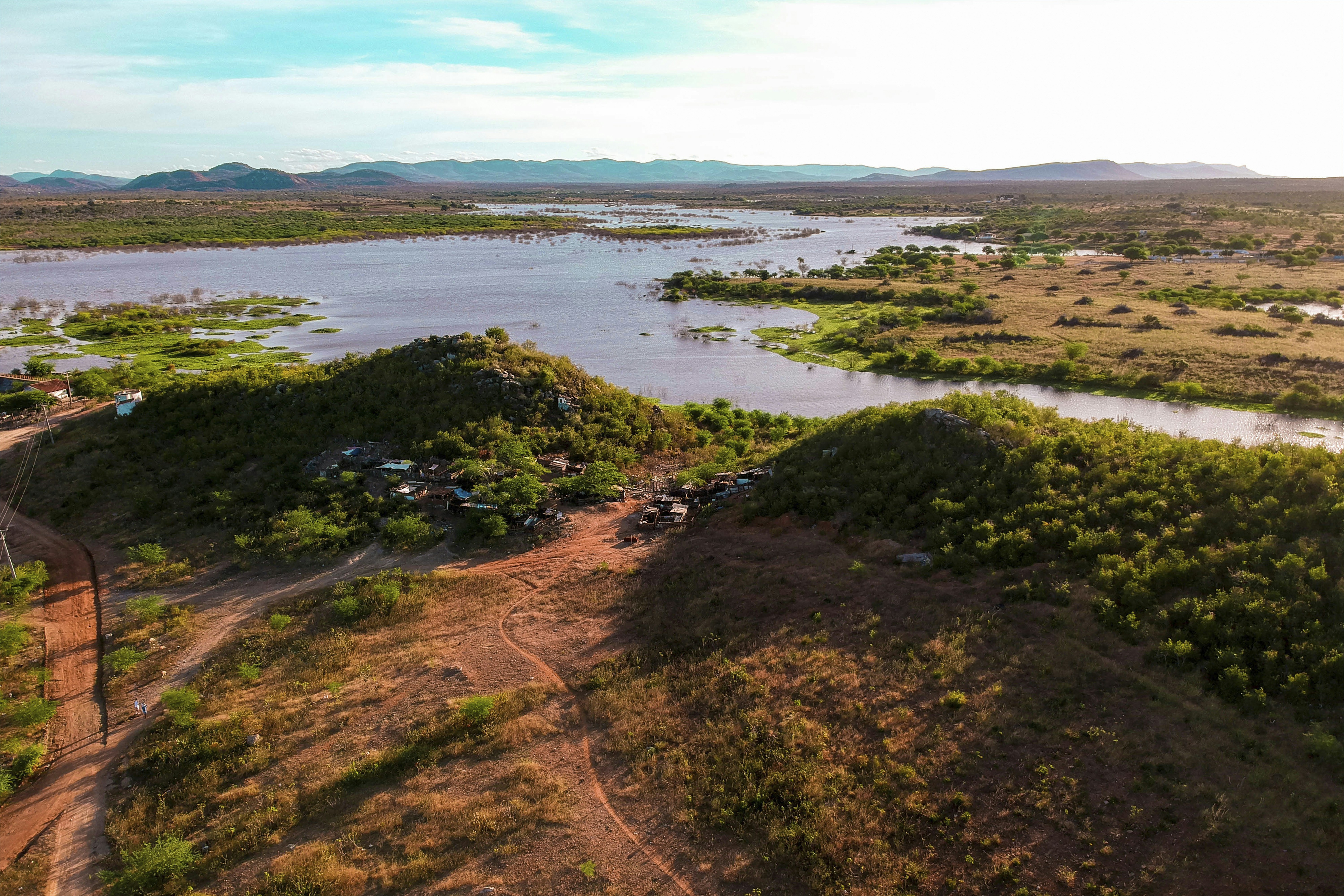 Aerial view of a vast lake surrounded by green hills.