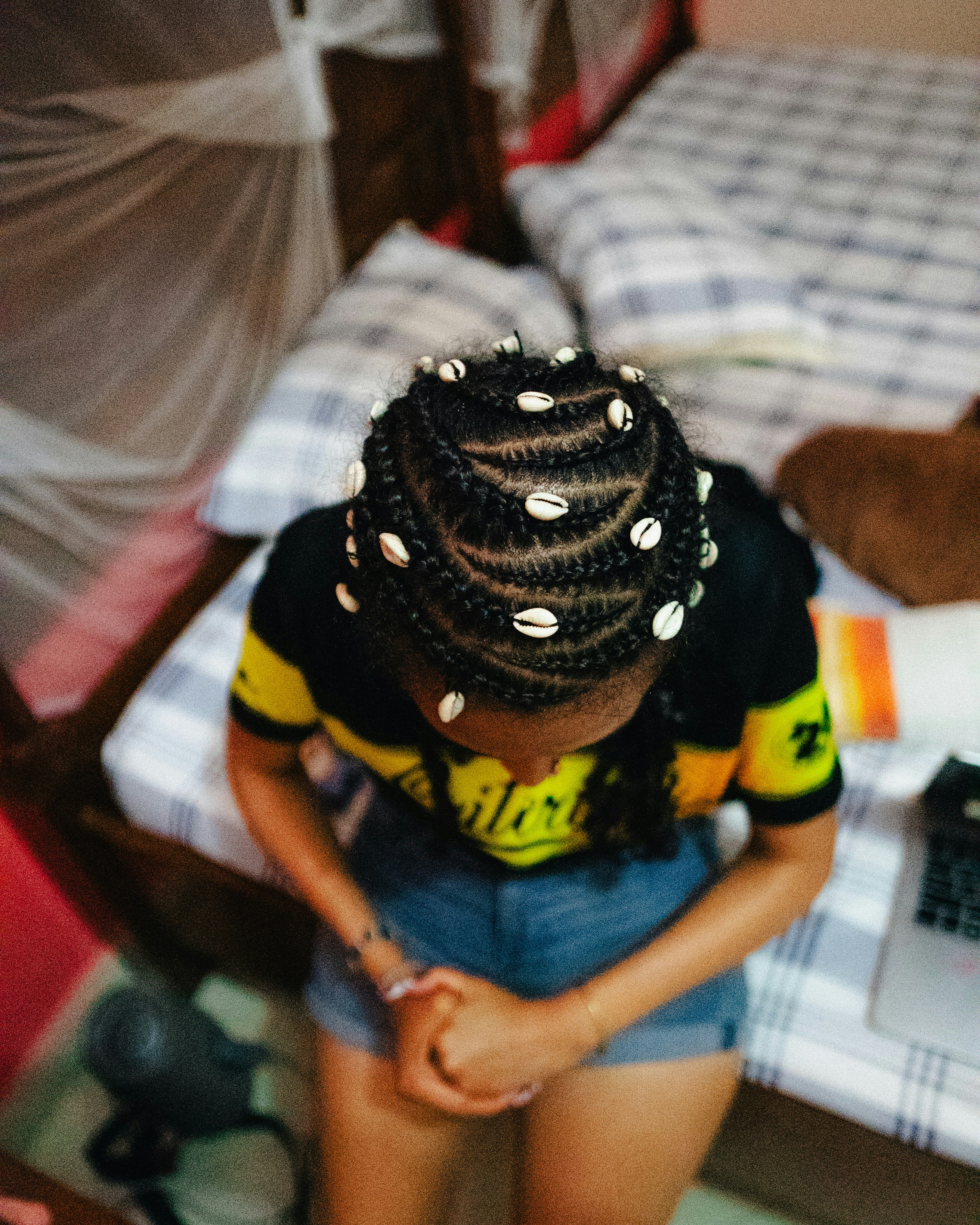 Woman with braided hair adorned with cowrie shells