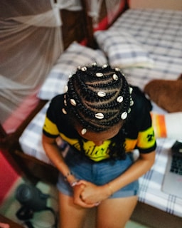 Woman with braided hair adorned with cowrie shells