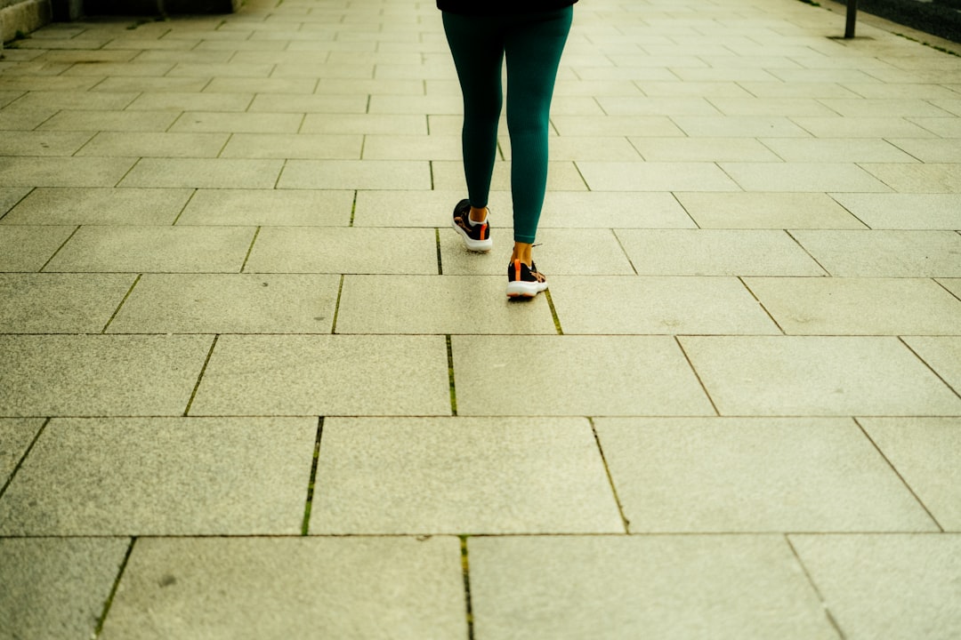 A person walking outdoors in a natural setting, taking one step at a time