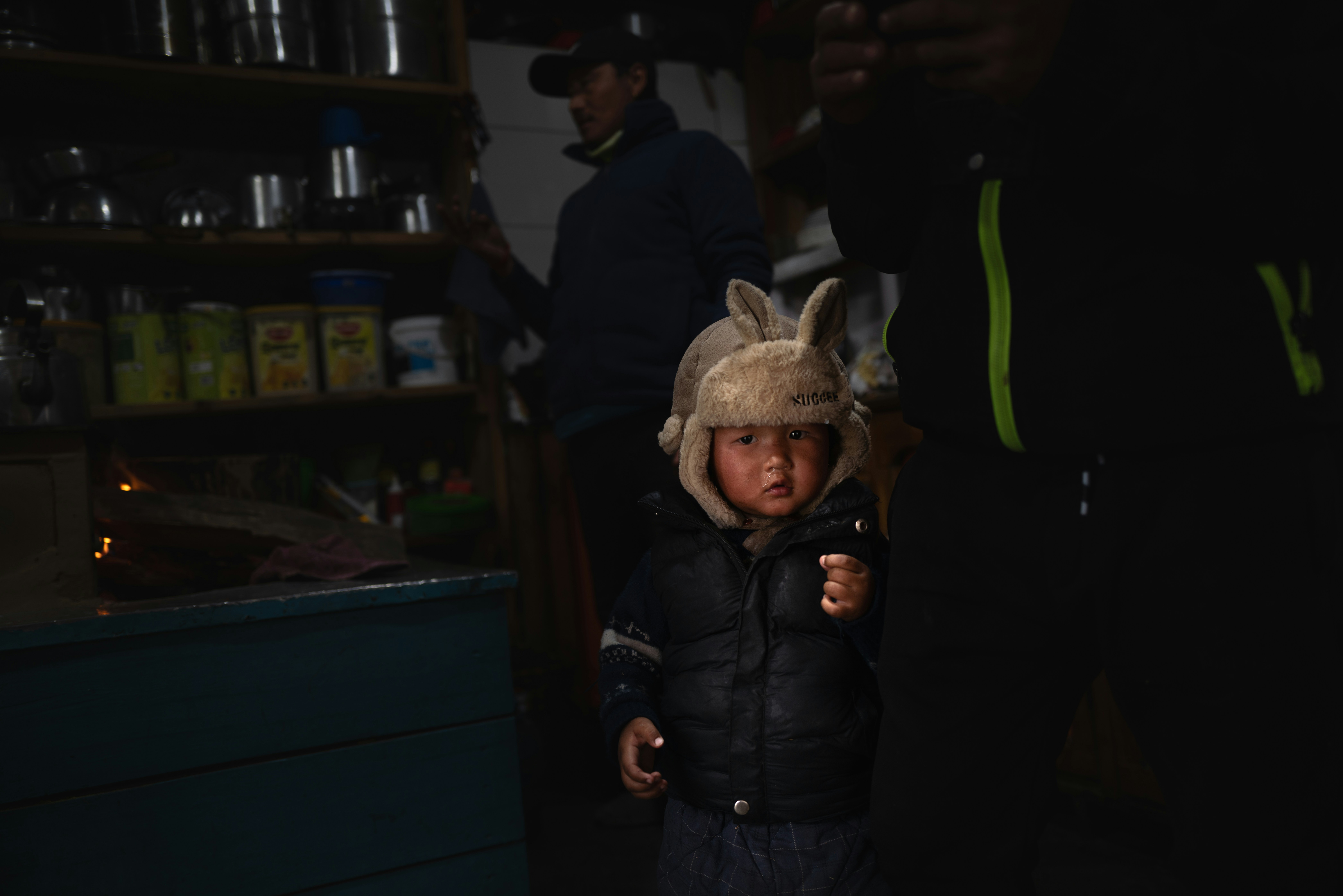 Child in a bunny hat and winter jacket indoors