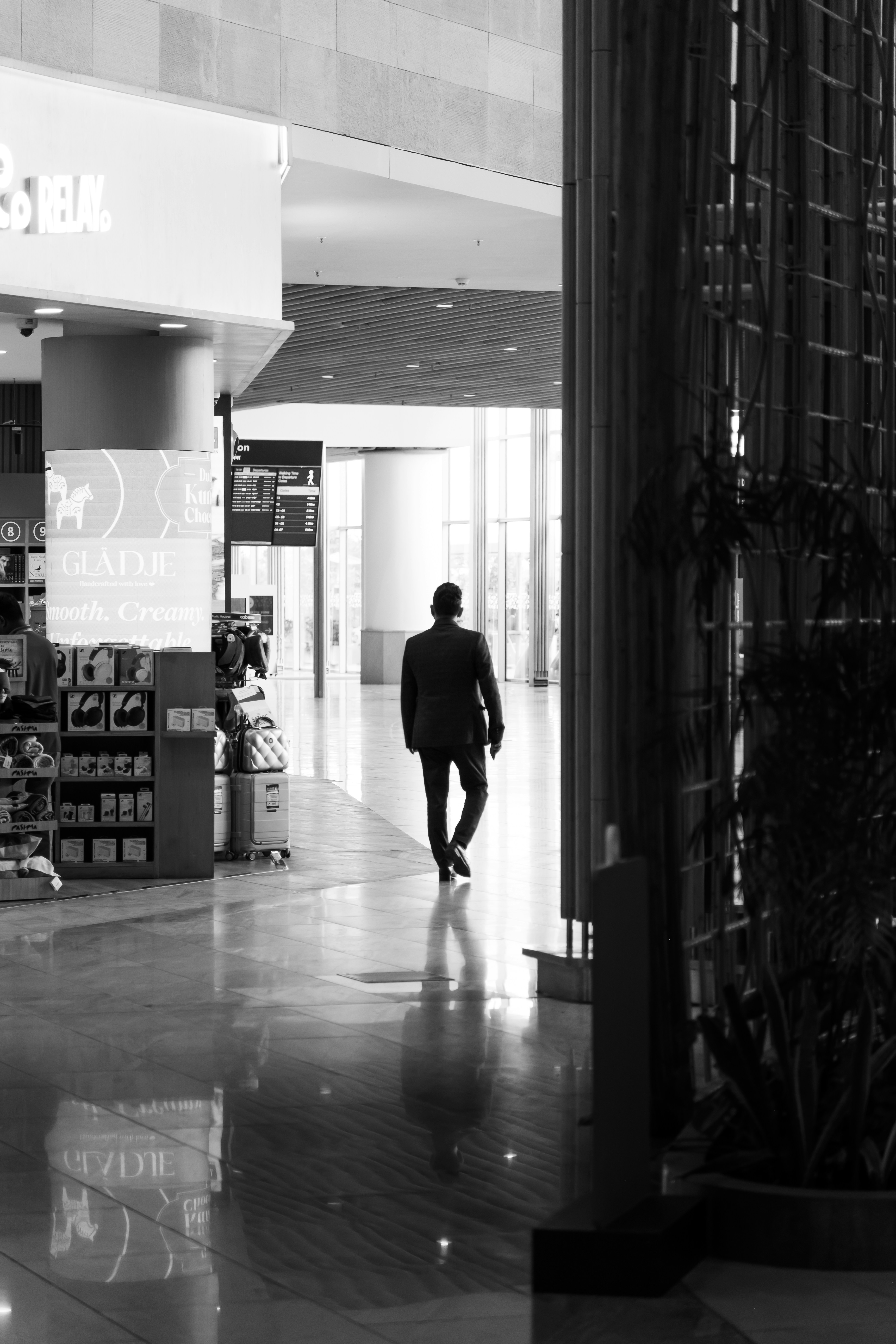 Man in suit walking down a modern hallway