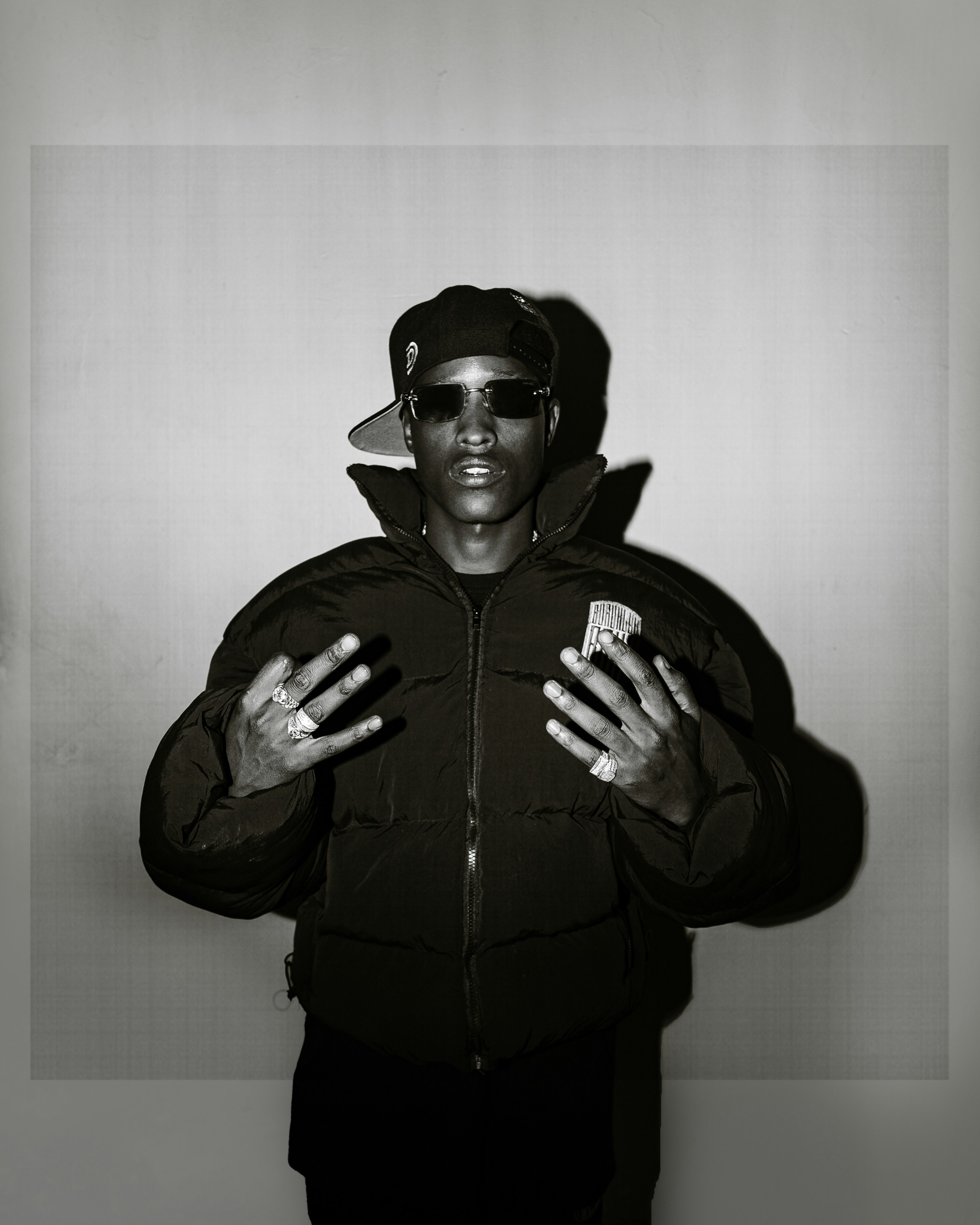 Man in puffer jacket and sunglasses posing