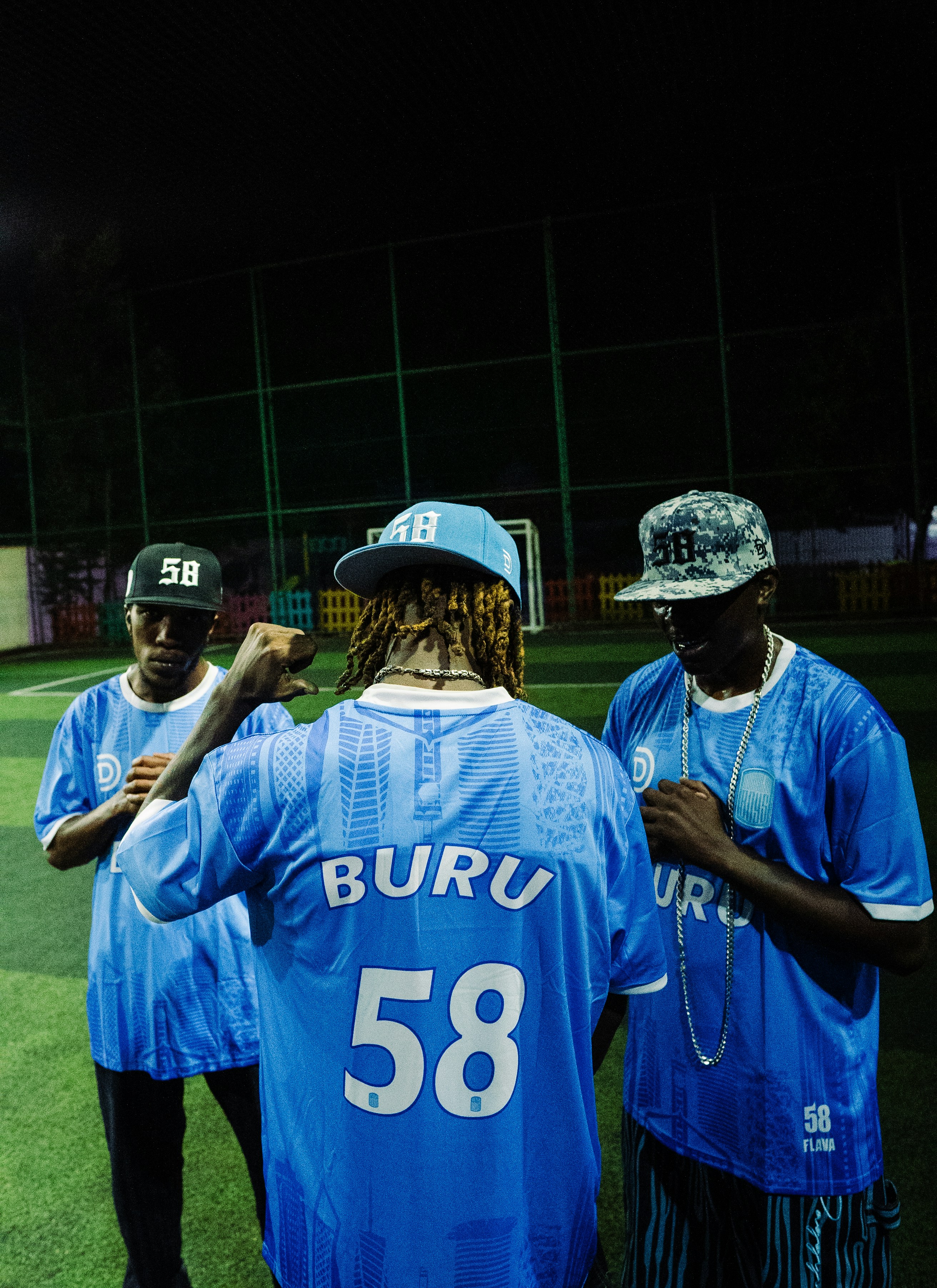 Three men in blue jerseys on a soccer field