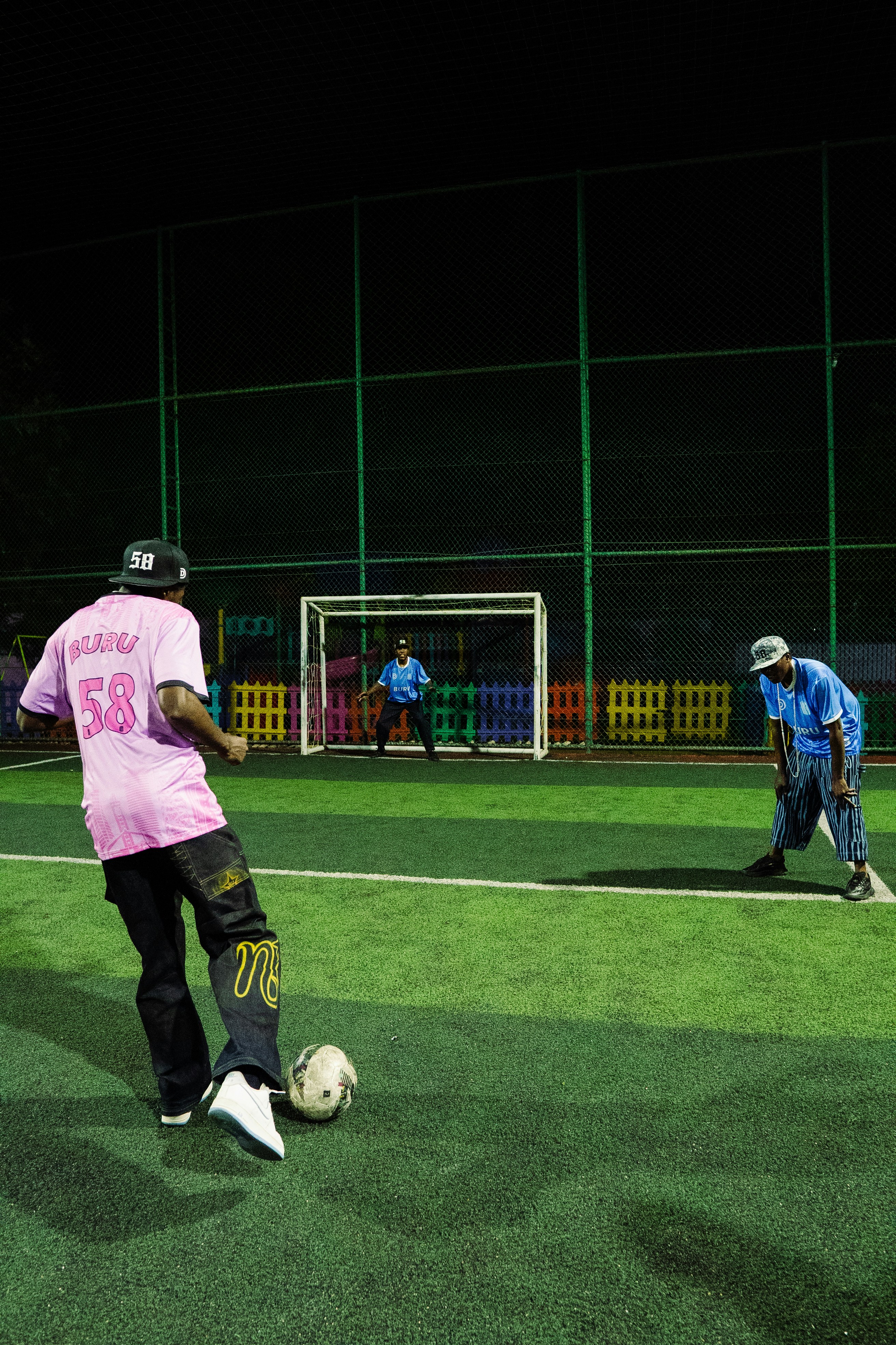 Soccer players practice on a field at night.