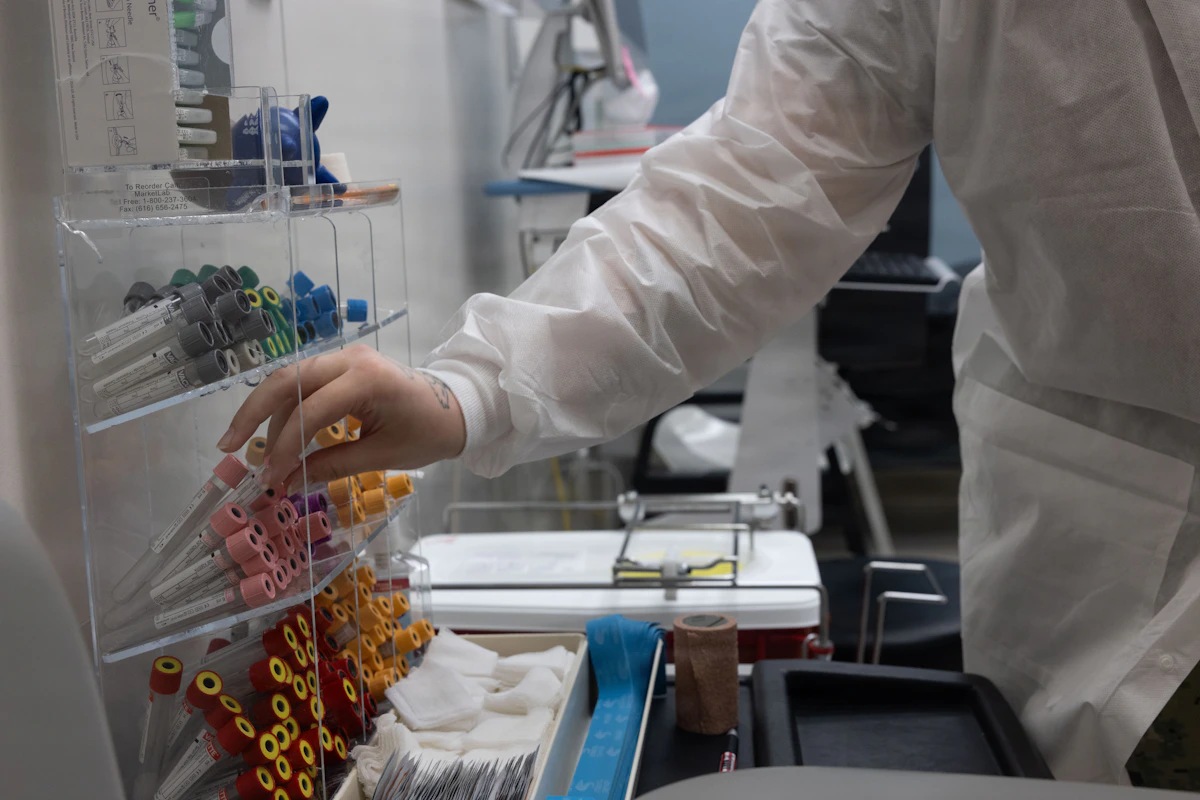 A healthcare worker in a lab coat selecting supplies from a storage rack