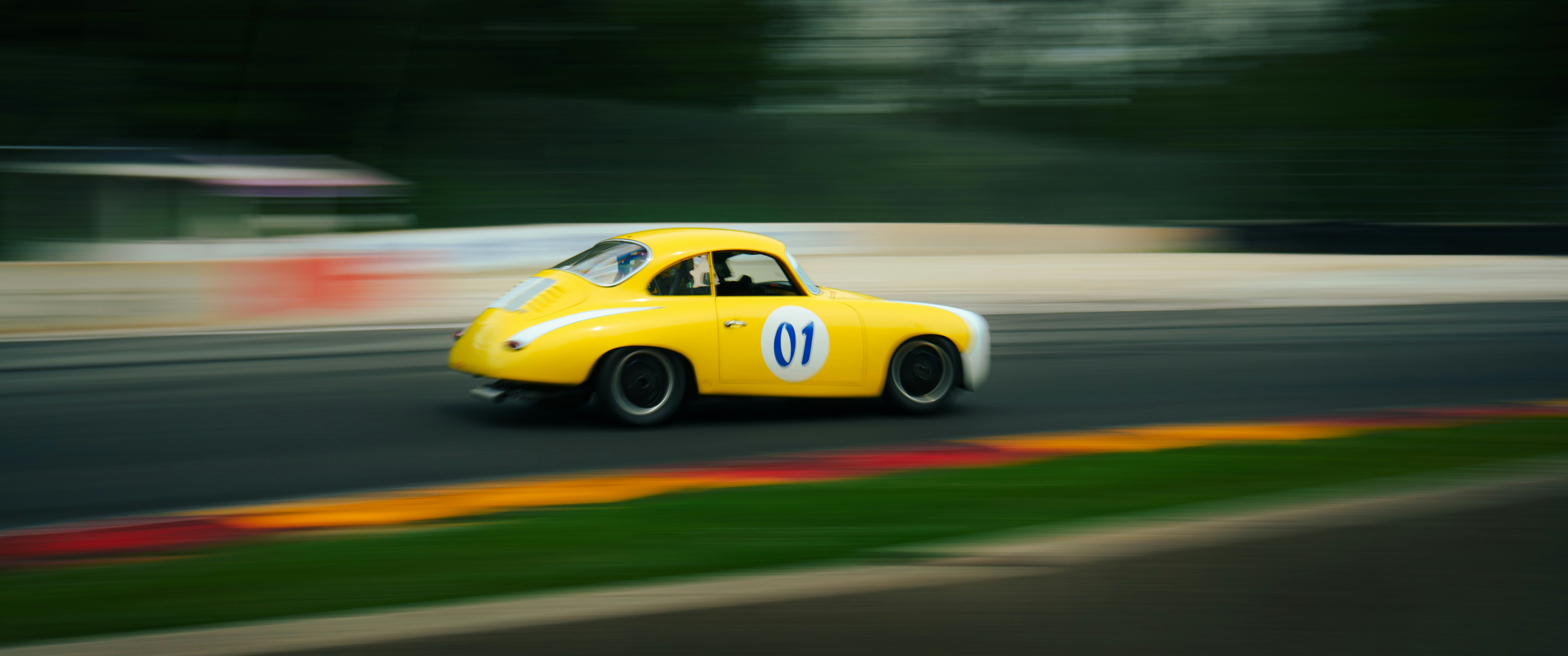 Yellow race car speeding on a track.