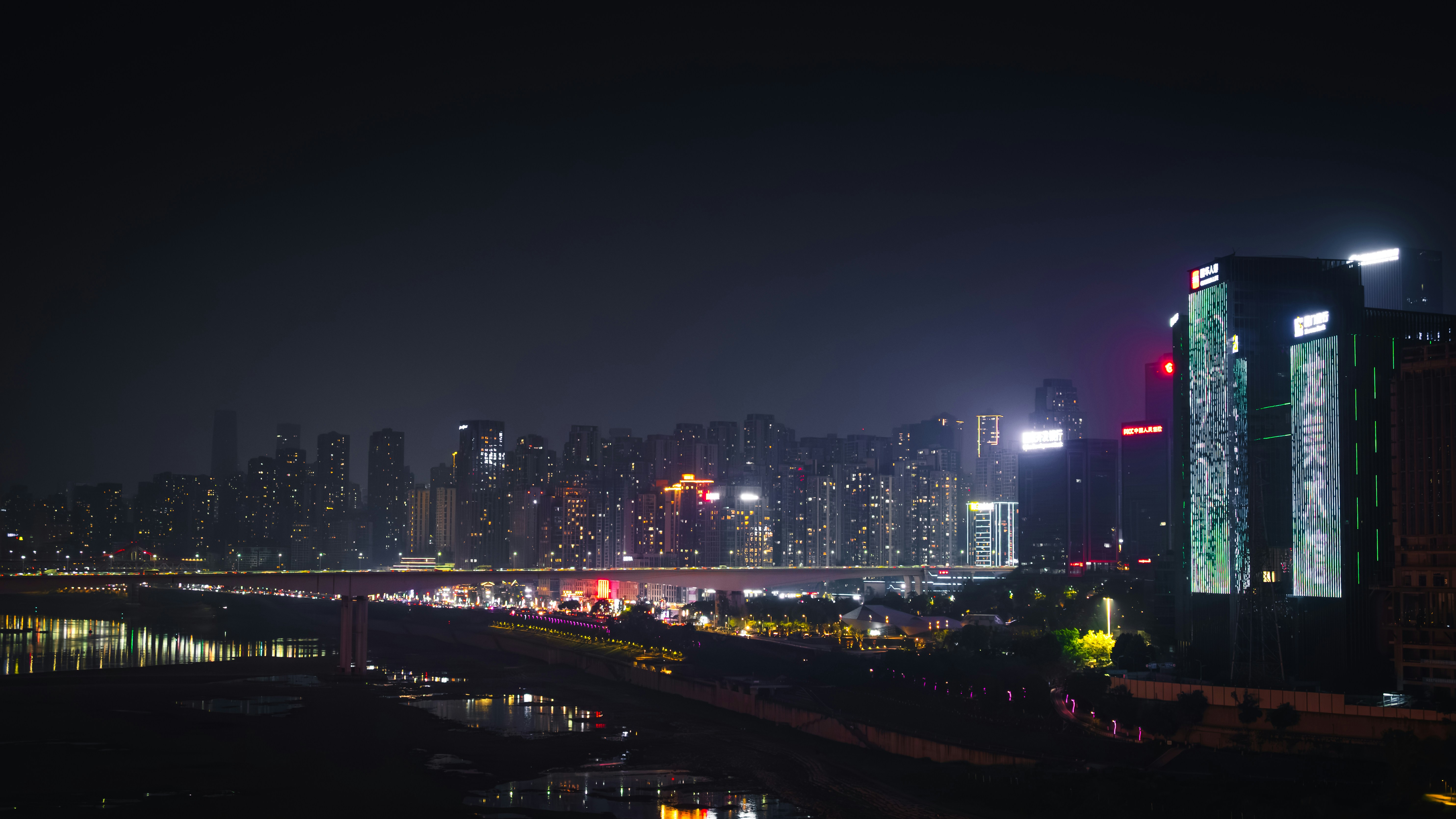 City skyline illuminated at night with river reflection