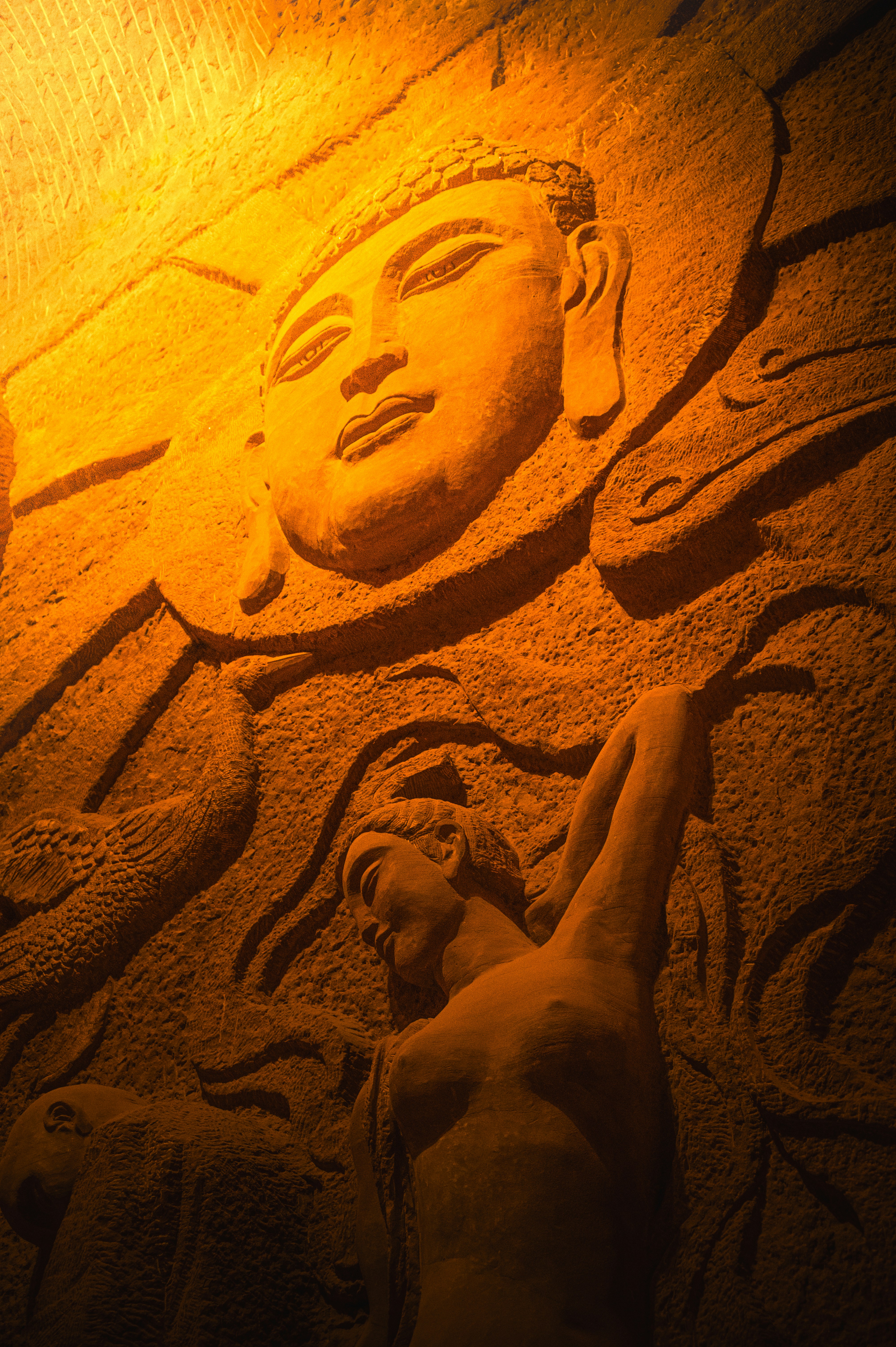 Stone carving of buddha face and a woman