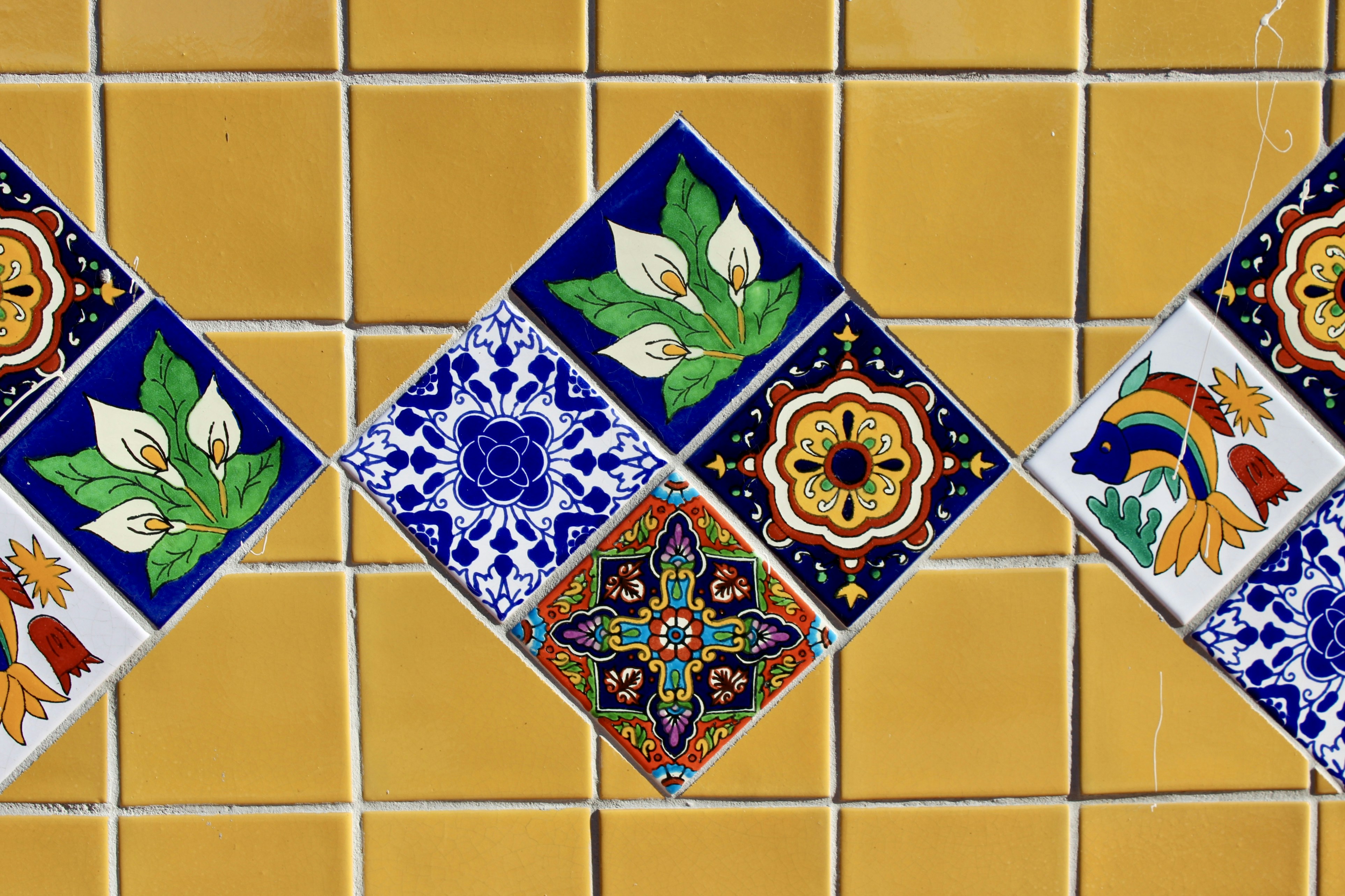 Yellow tiles with decorative diamond patterned tiles.