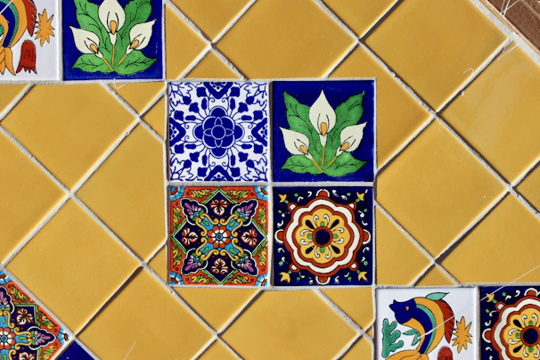 Colorful decorative tiles arranged on a yellow tiled wall