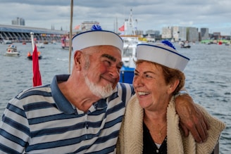 Couple in sailor hats on a boat with city background