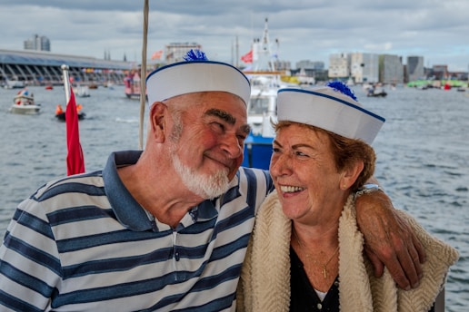 Couple in sailor hats on a boat with city background