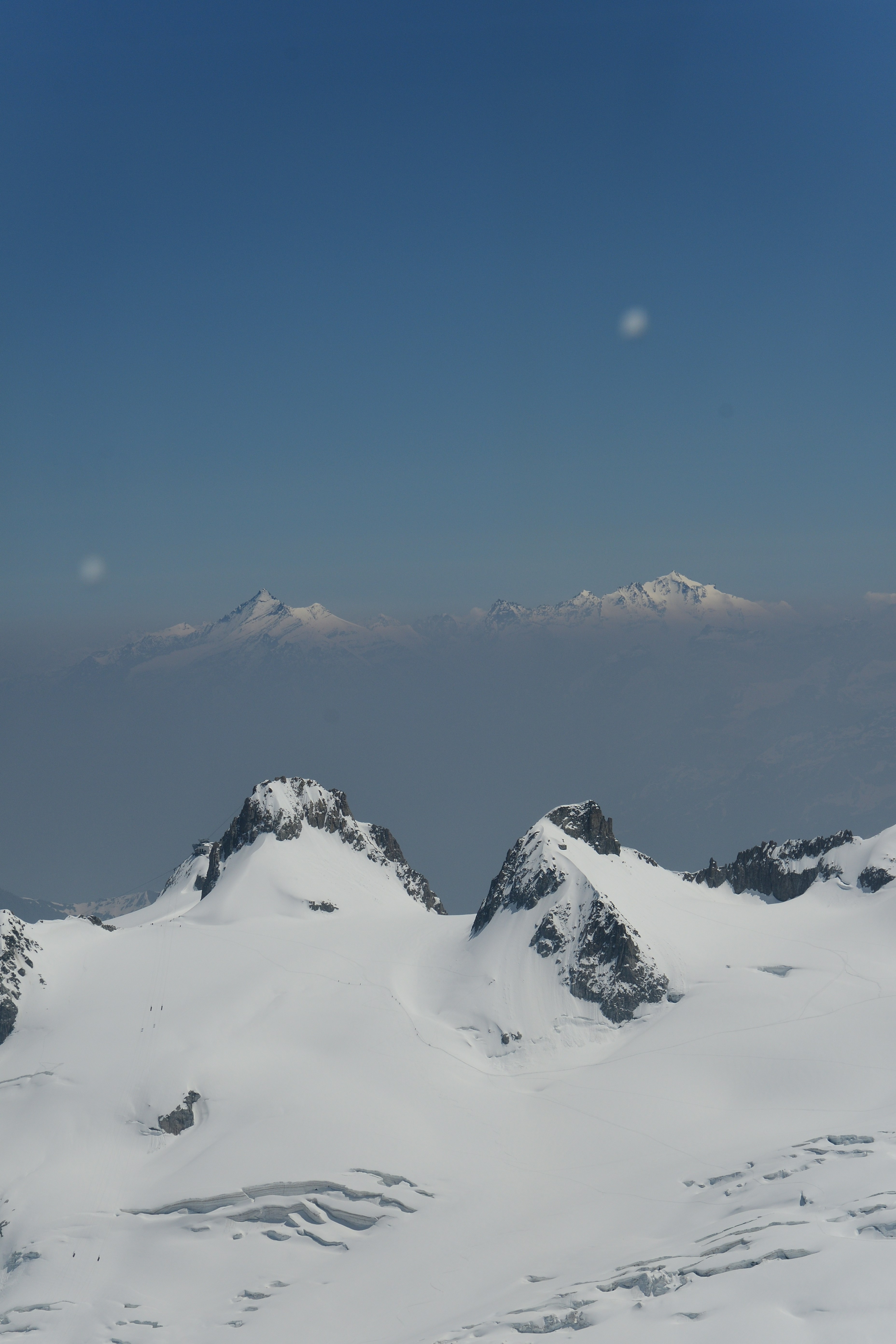 澄んだ青空の下、雪に覆われた山頂