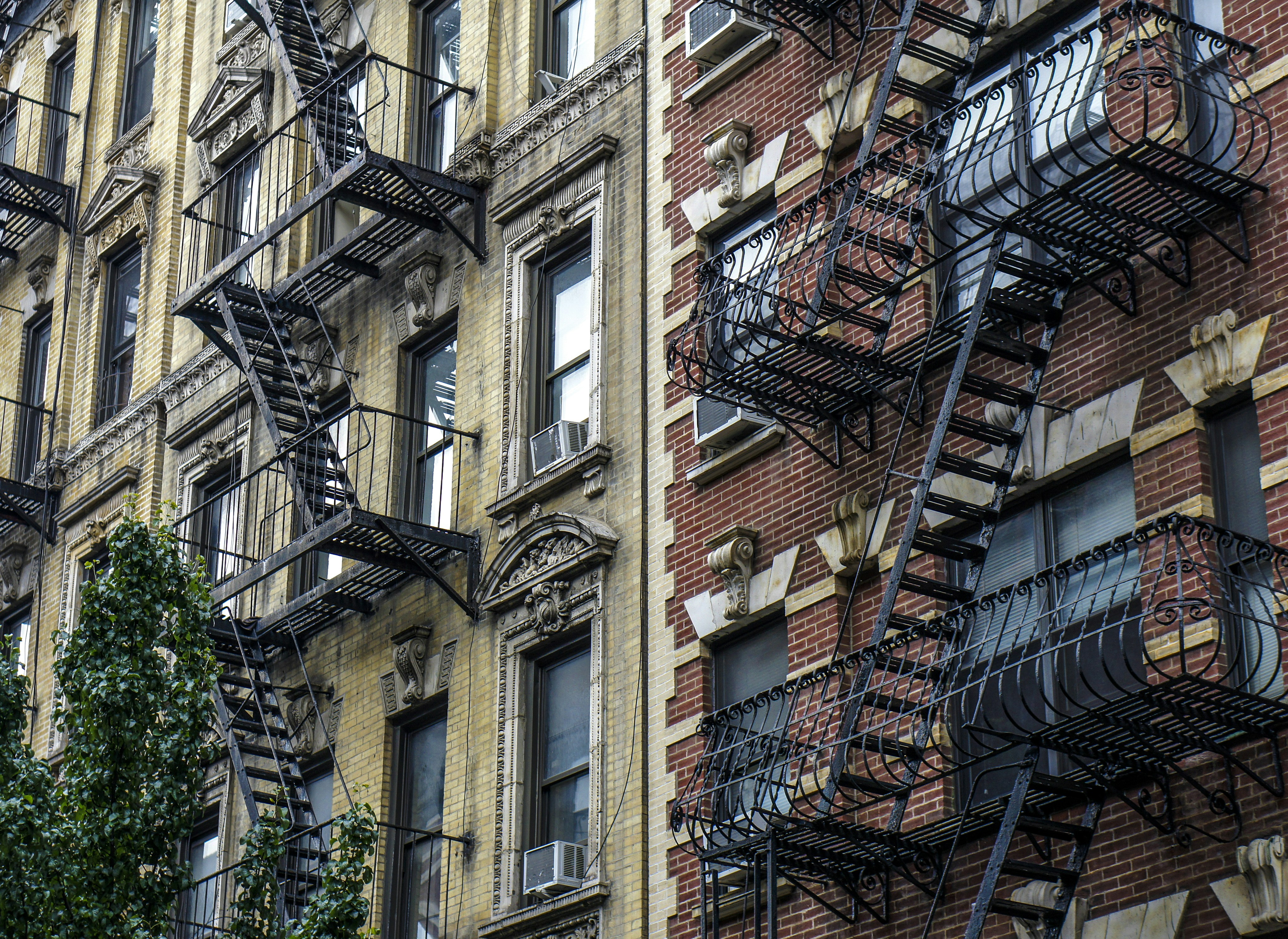 Apartment buildings with ornate fire escapes and air conditioners