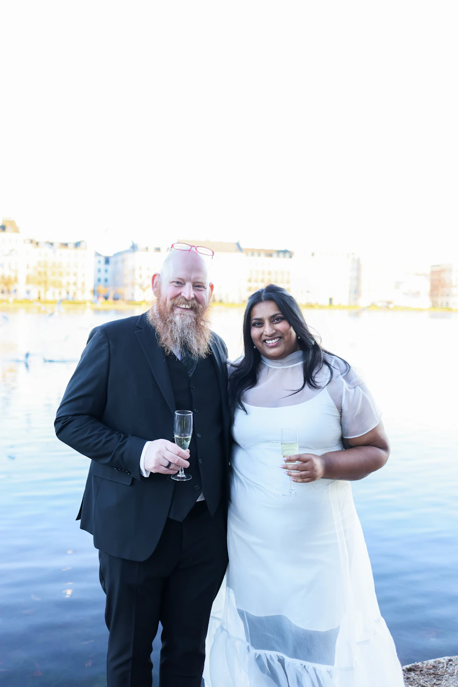 Smiling couple raising champagne glasses at an anniversary celebration