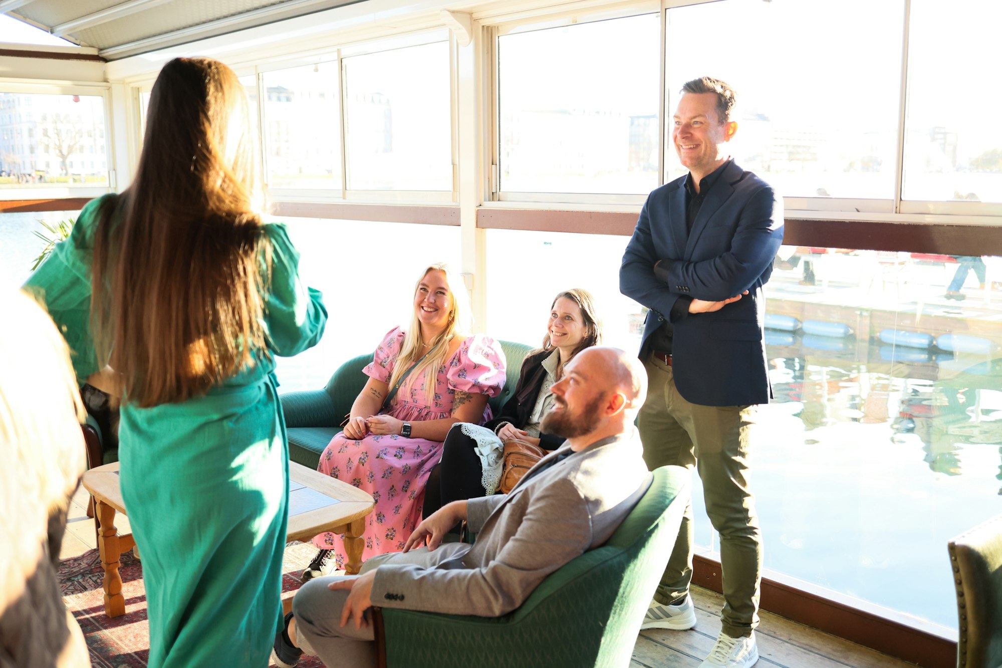 Group of professionals talking and networking indoors near a window at a business event