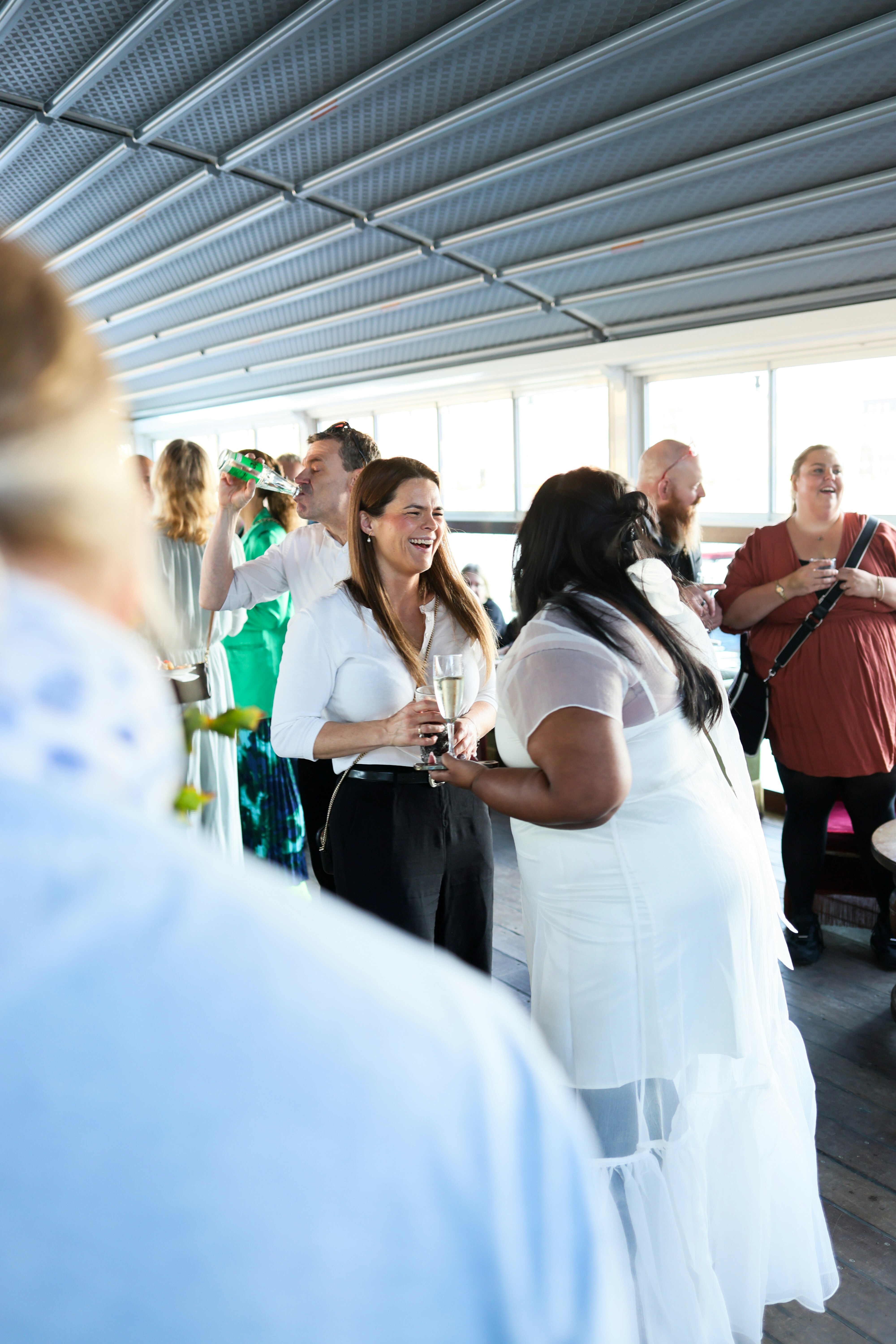People mingling and holding drinks at an event.