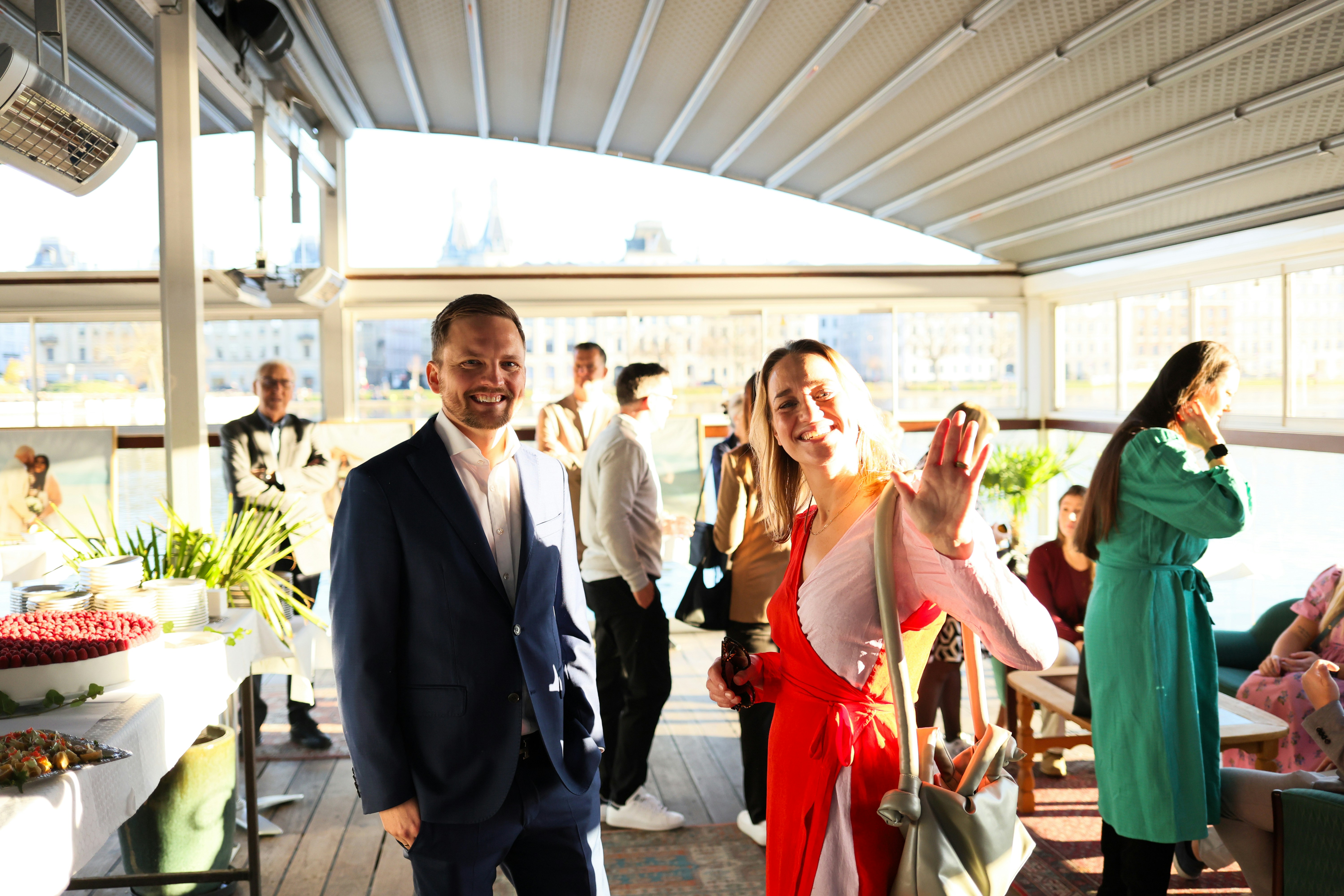 People mingling at an outdoor event with food spread.