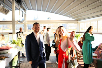 People mingling at an outdoor event with food spread.
