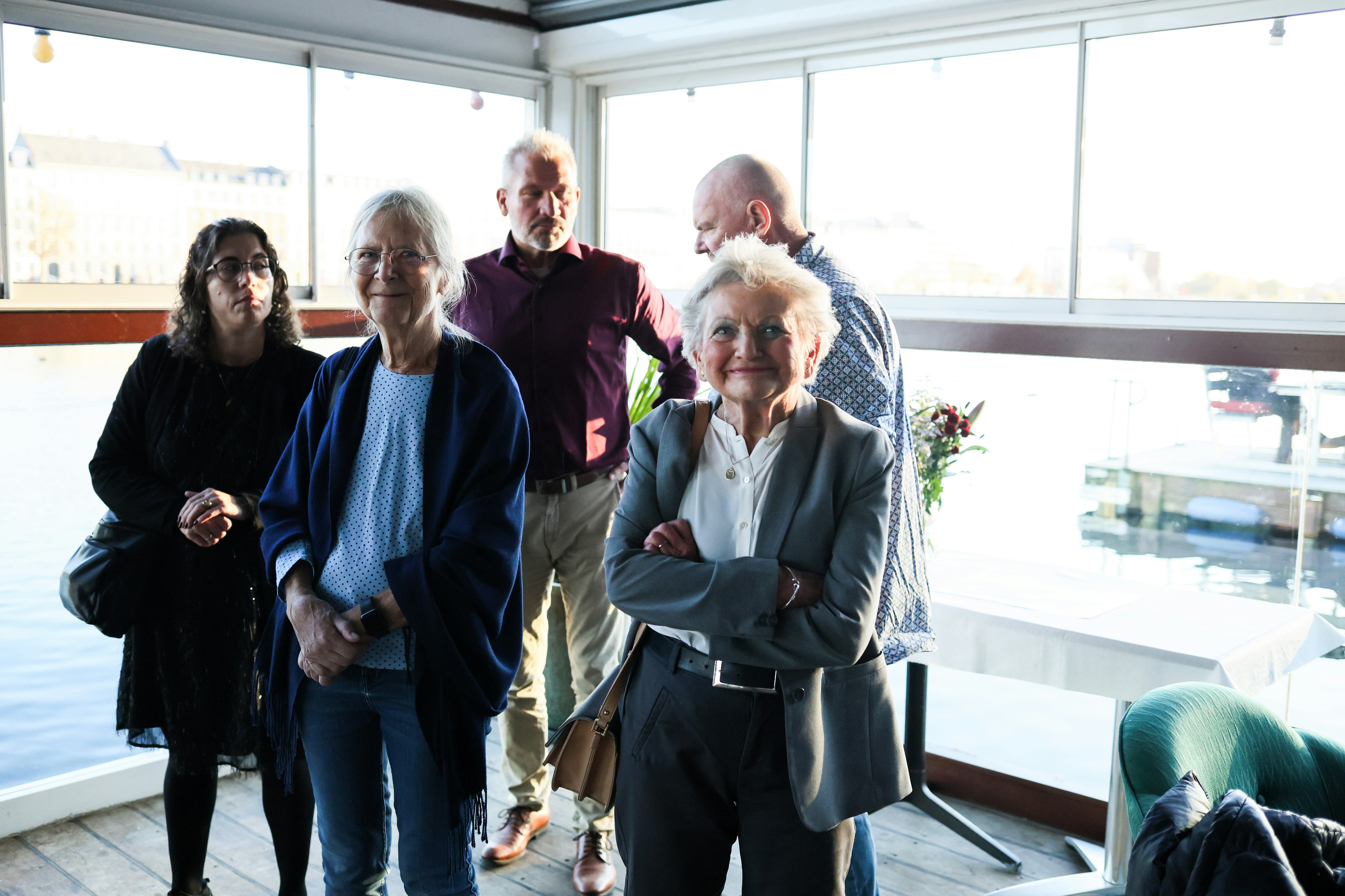 Group of people standing indoors near a window