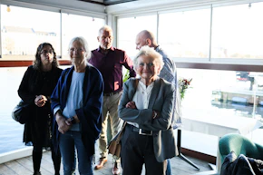 Group of people standing indoors near a window