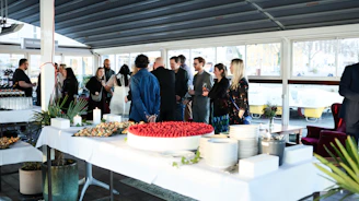 People mingling around a buffet table at an event.
