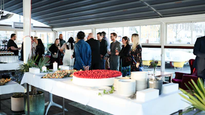 People mingling around a buffet table at an event.