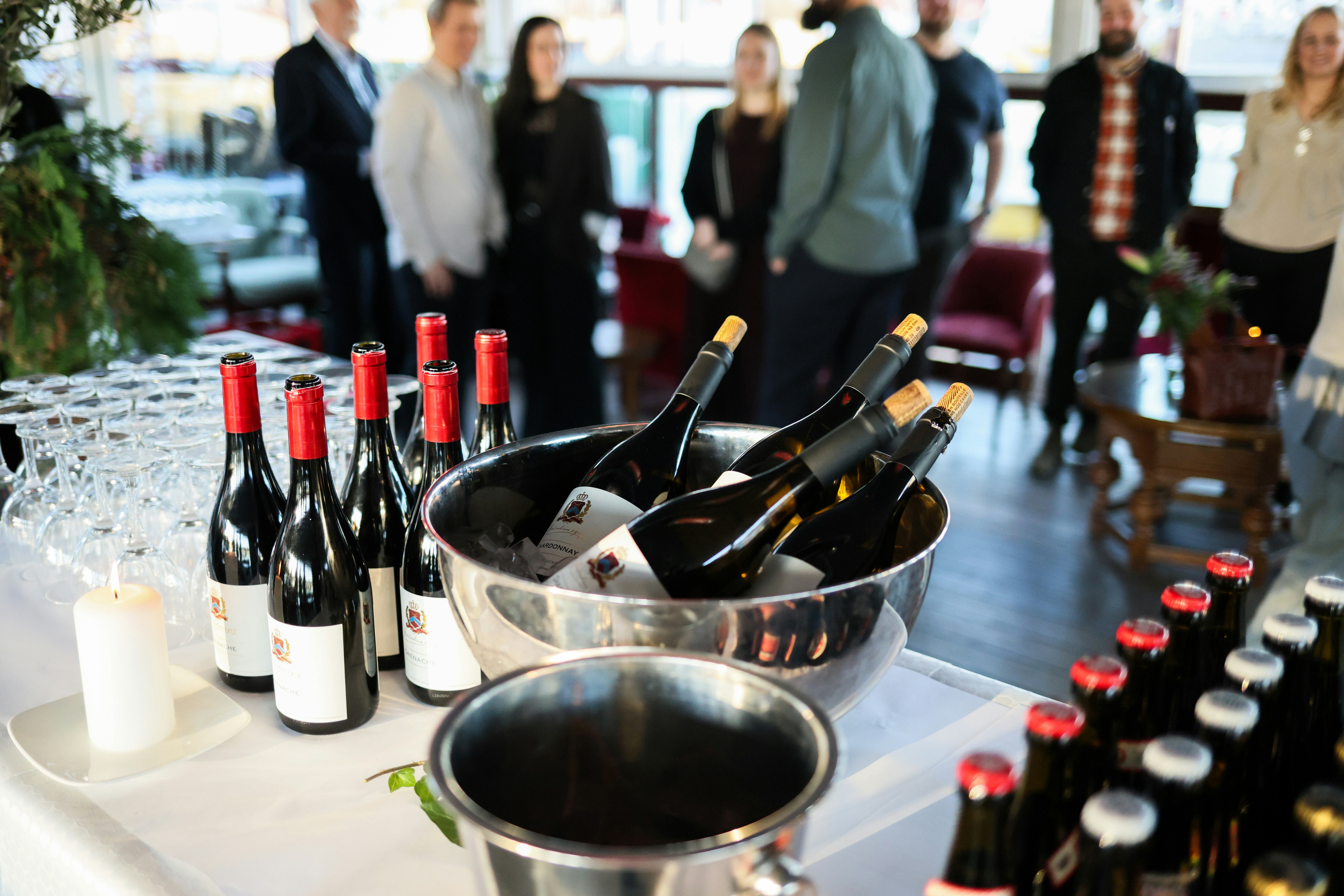 Bottles of wine chilling in ice buckets at a party.