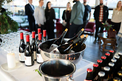 Bottles of wine chilling in ice buckets at a party.