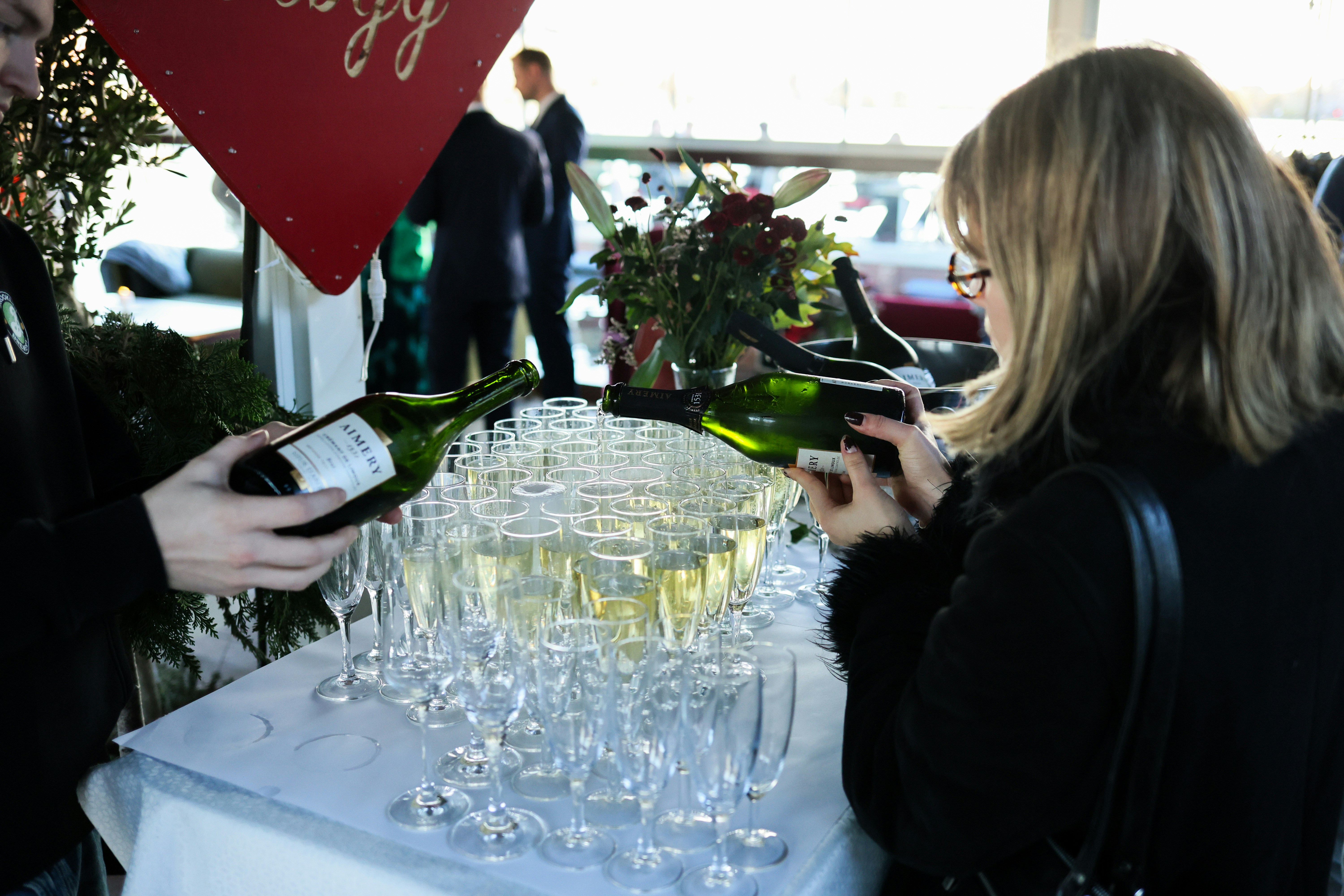Bartender pouring champagne into glasses at event.