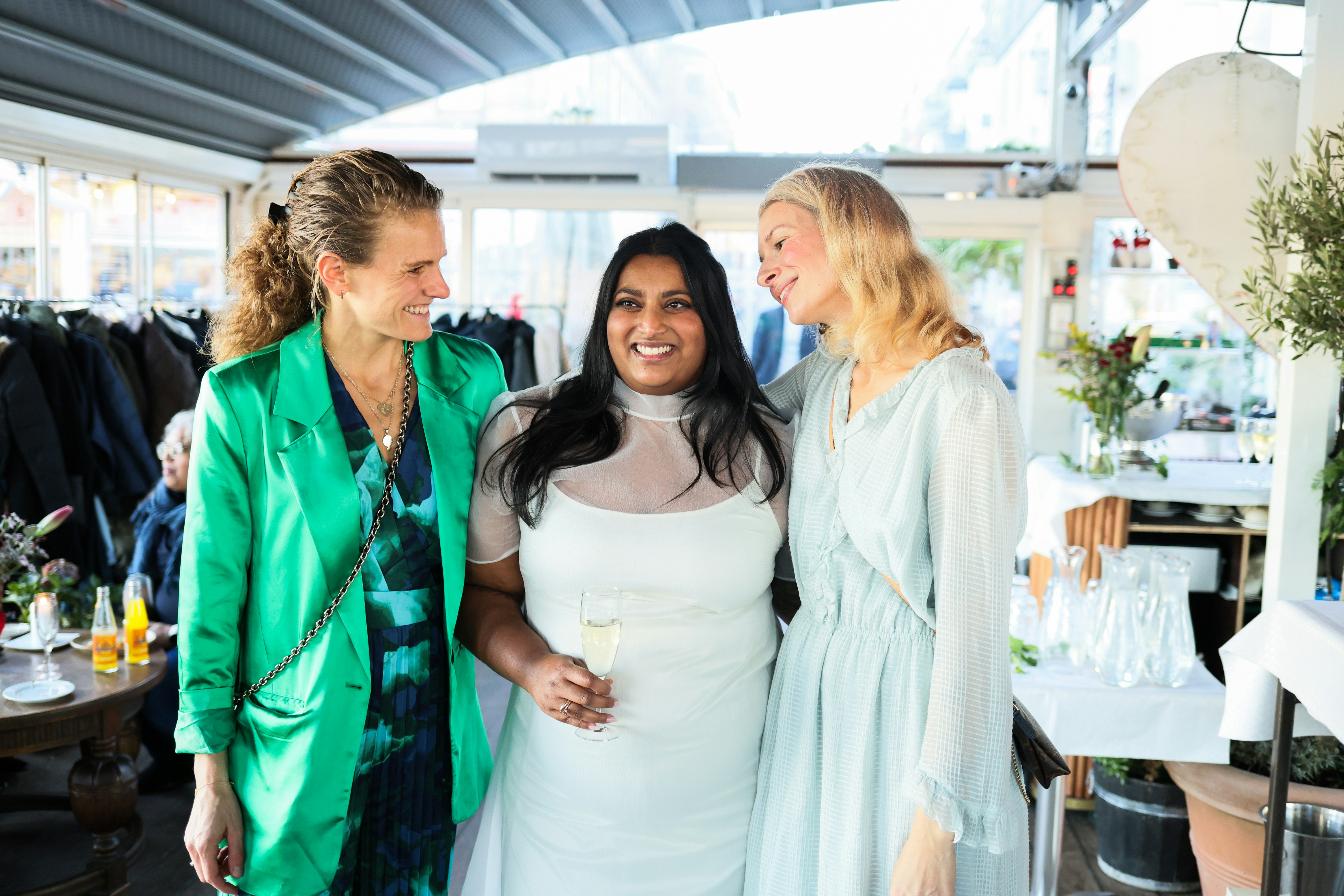 Three women smiling together indoors