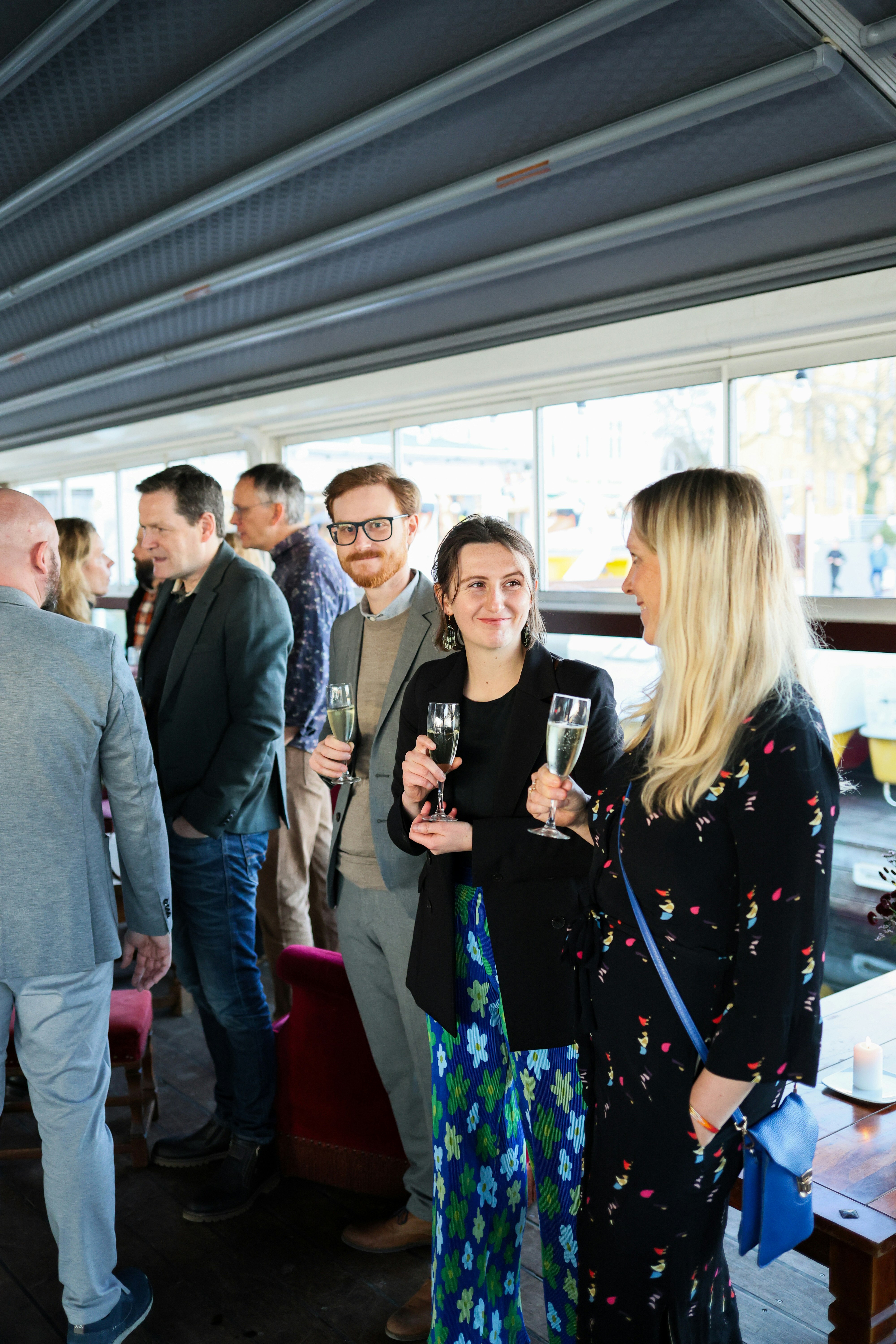 People holding champagne glasses at a social gathering.