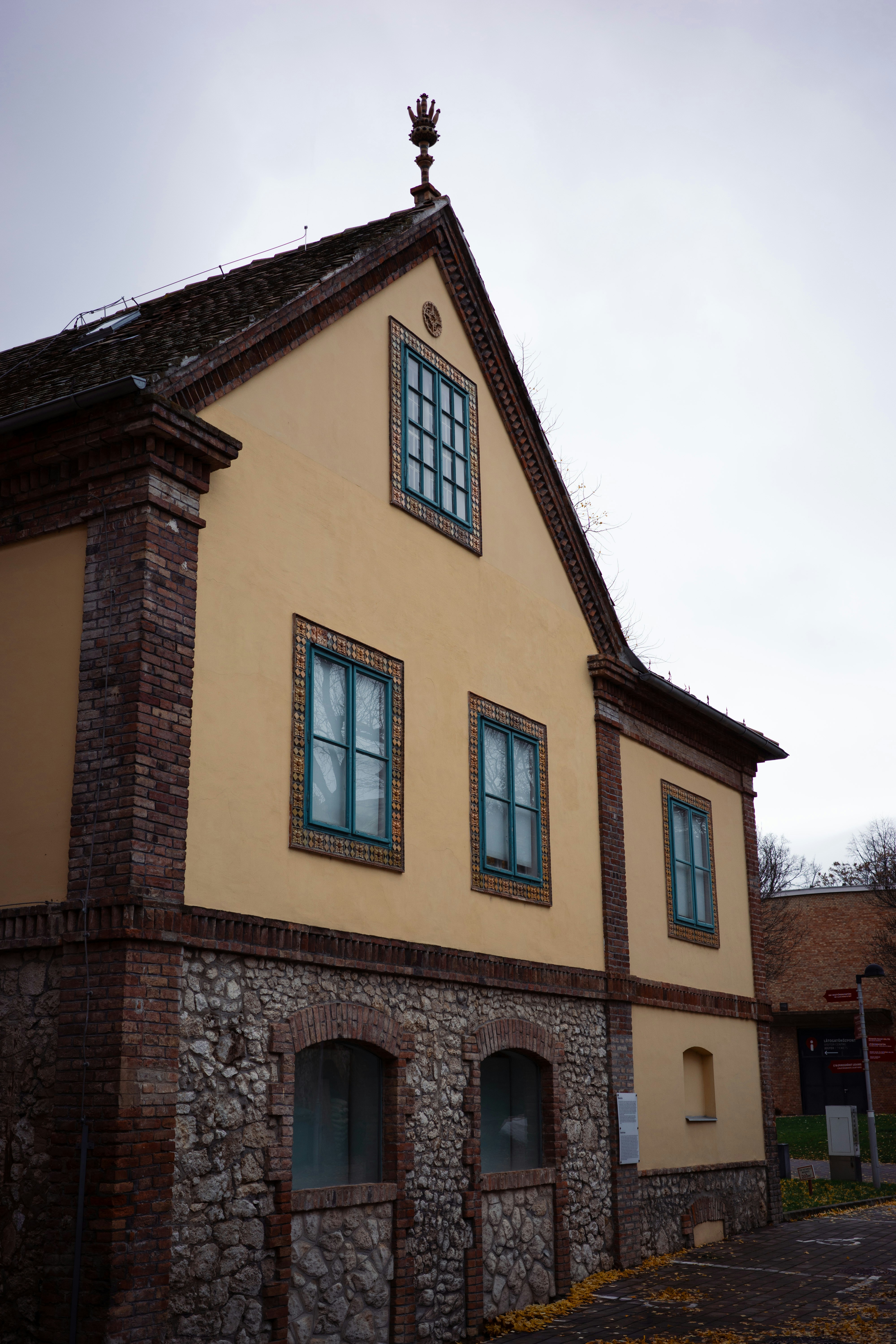Yellow building with stone base and teal windows