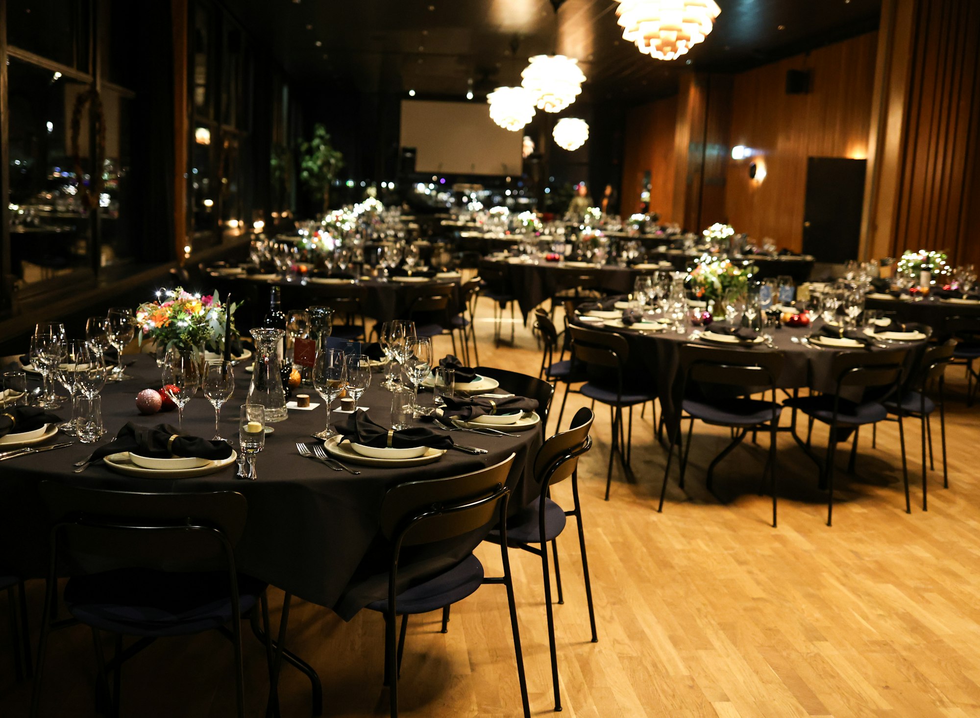 Elegant banquet hall set for a formal dinner event with round tables and ambient lighting