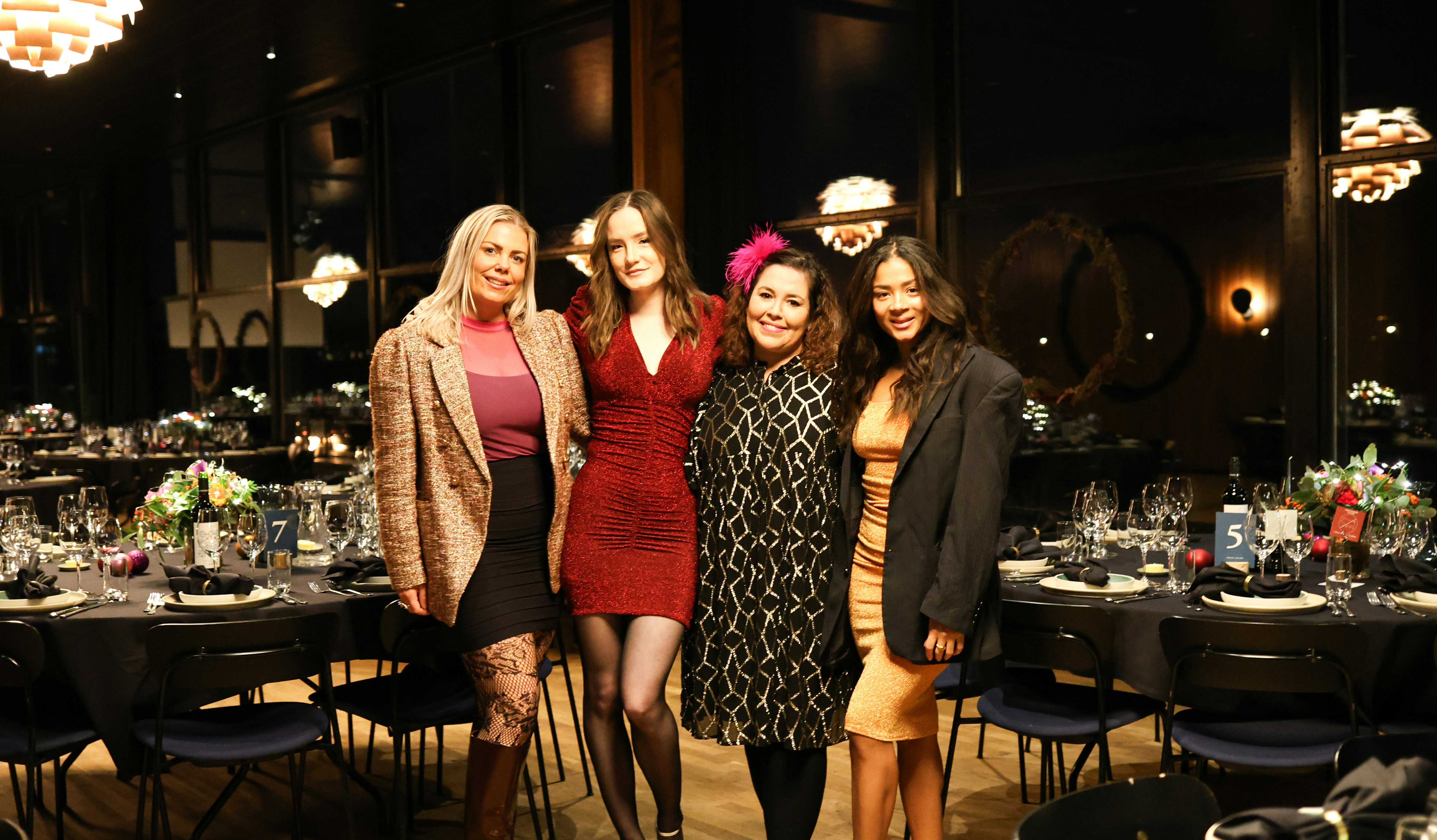 Four women posing at a formal event