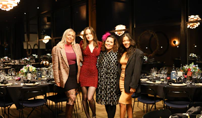 Four women posing at a formal event